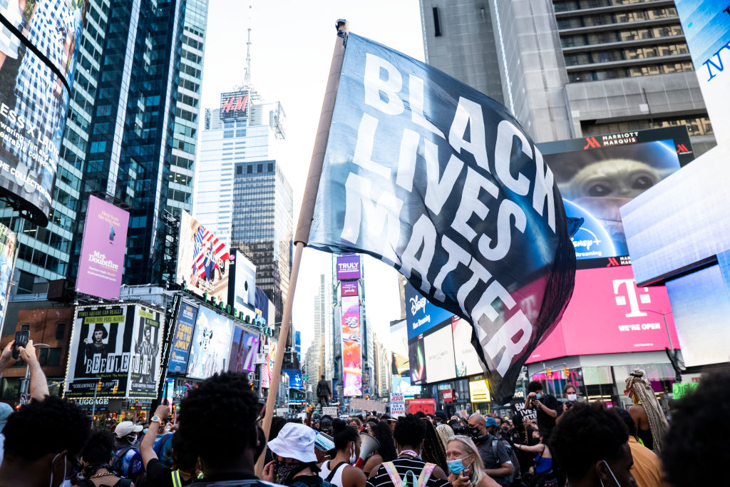 A protester holds a large flag that says, "Black Lives Matter" during a peaceful protest in New York City's Times Square on July 26, 2020. (Corbis via Getty Images&mdash;2020 Ira L. Black)