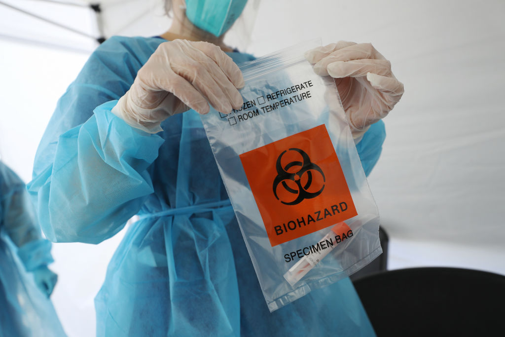 A nurse seals a specimen bag containing a COVID-19 test swab at a St. John’s Well Child & Family Center mobile clinic set up outside Walker Temple AME Church in South Los Angeles amid the coronavirus pandemic on July 15, 2020 in Los Angeles, California. (Mario Tama—Getty Images)