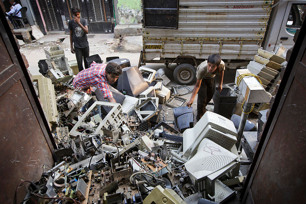 Workers sort through used computers and other electronic waste at a workshop in New Delhi, India. (Kuni Takahashi—Getty)