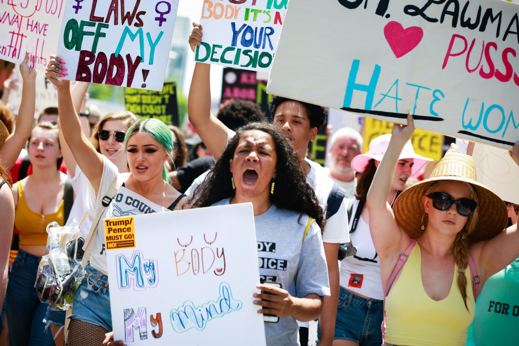 Demonstrators hold signs during a protest against  Georgia’s law banning most abortions after six weeks outside of the Georgia State Capitol building in Atlanta on May 25, 2019. A federal judge permanently struck down the law on Monday, ruling that it violates the U.S. Constitution. (Elijah Nouvelage/Bloomberg—Getty Images)