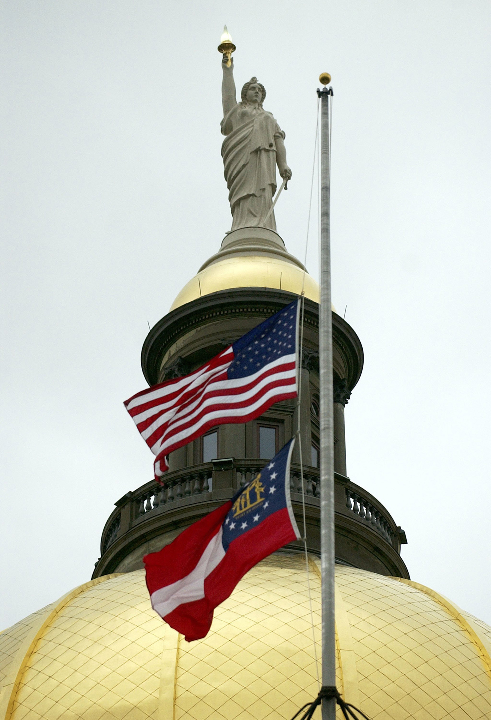Flags atop Georgia's state Capitol fly at half staff in Atlanta on Feb. 4, 2006. (Stephen Morton—Getty Images)