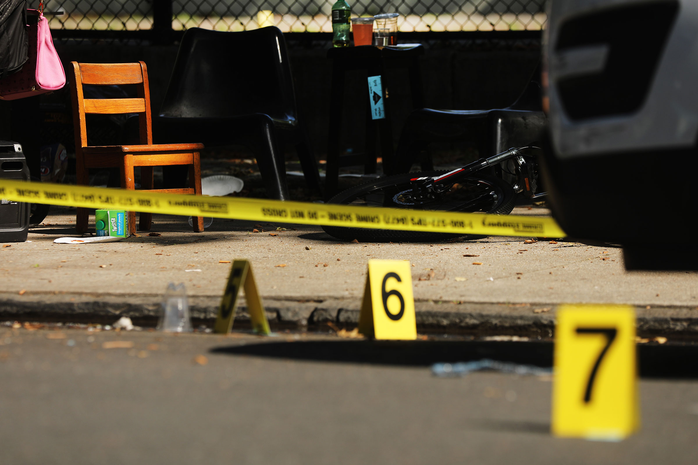 Police ballistic markers stand beside a child's chair and bicycle at a crime scene in Brooklyn where a one year old child was shot and killed on July 13, 2020 in New York City. The 1-year-old boy was shot near a playground during a Sunday picnic when gunfire erupted. (Spencer Platt—Getty Images)