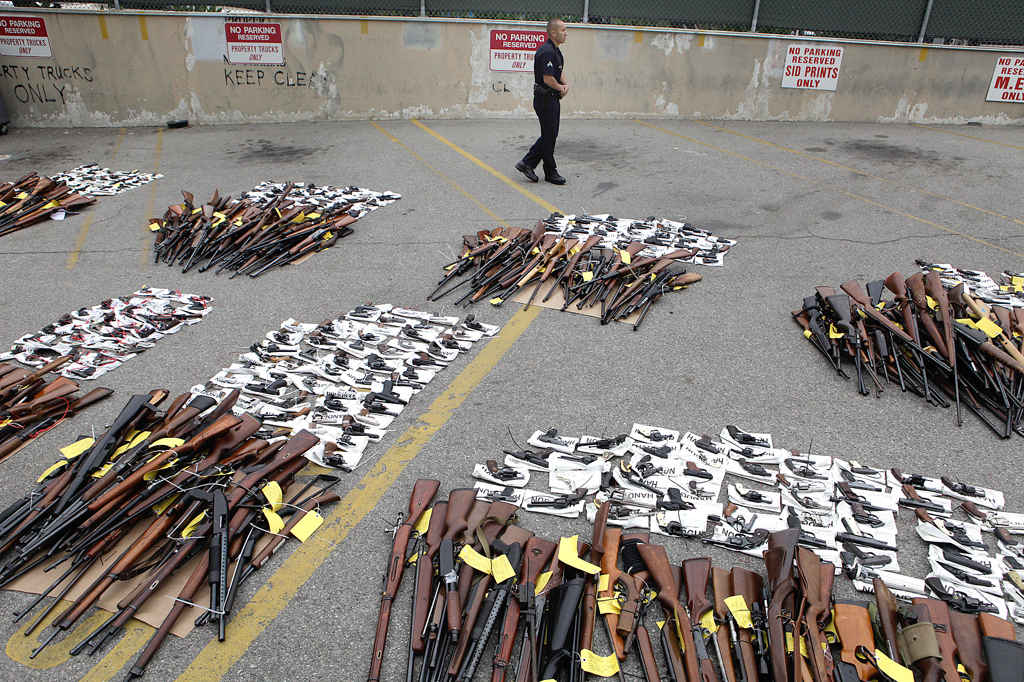 LAPD officer Manuel Ramirez stands guard near some of the nearly 1,700 weapons turned over the weekend at a news conference on May 11, 2009. (Brian Vander Brug—Los Angeles Times/Getty Images)