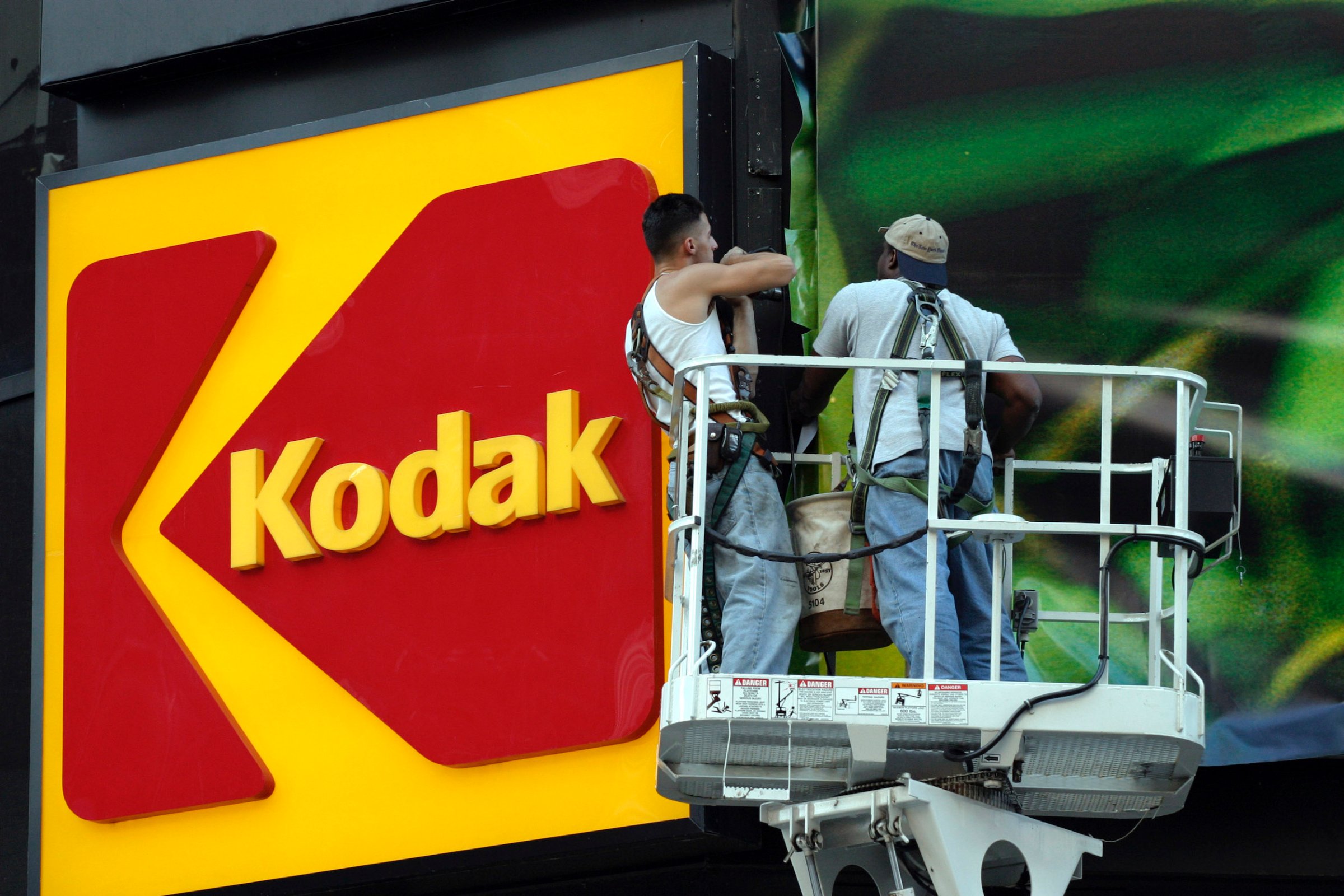 Workers stand near the KODAK billboard at Times Square, New York City.