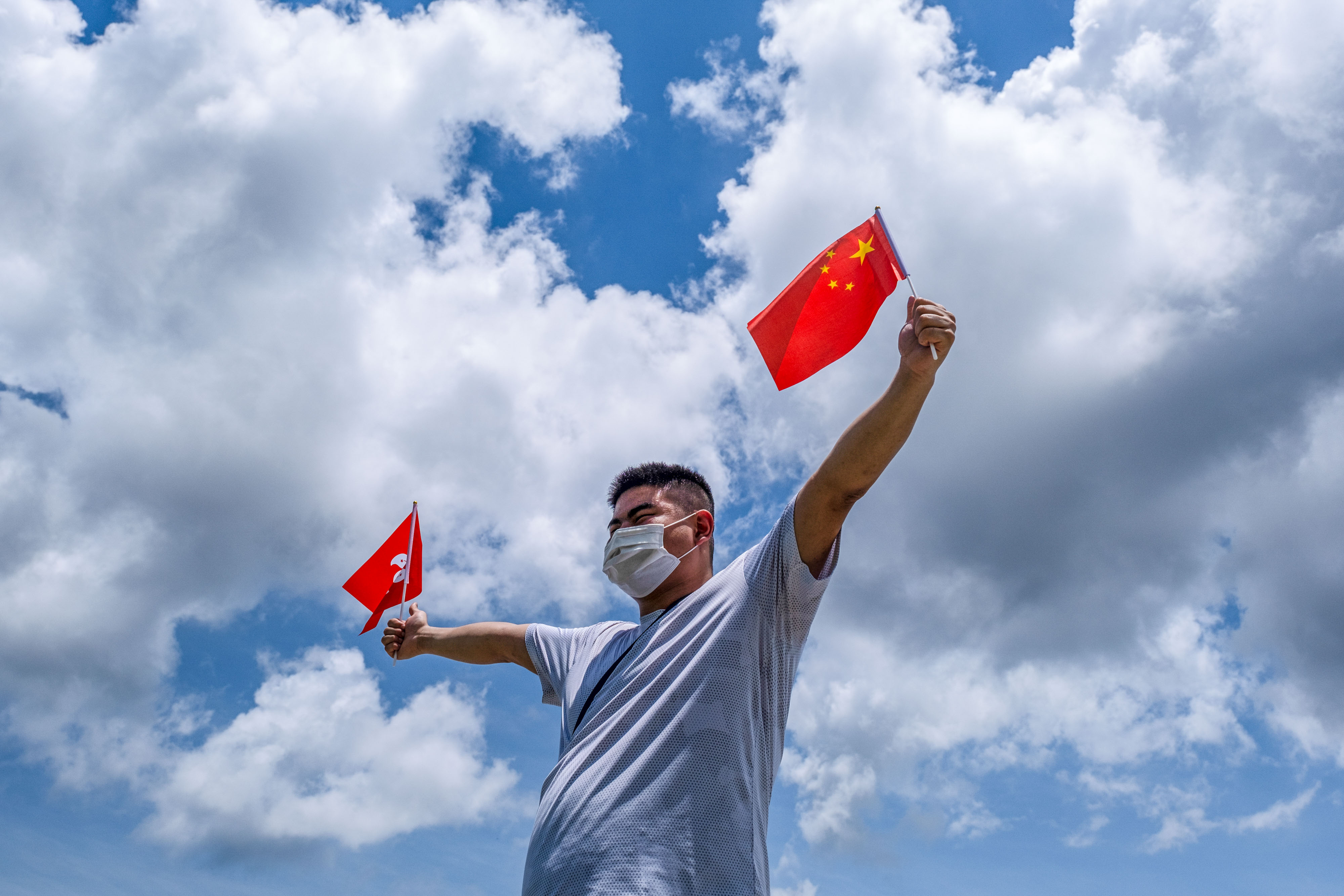A pro-China supporter waves Chinese and Hong Kong flags during a rally on June 30, 2020. (Chan Long Hei—SOPA Images/Getty Images)