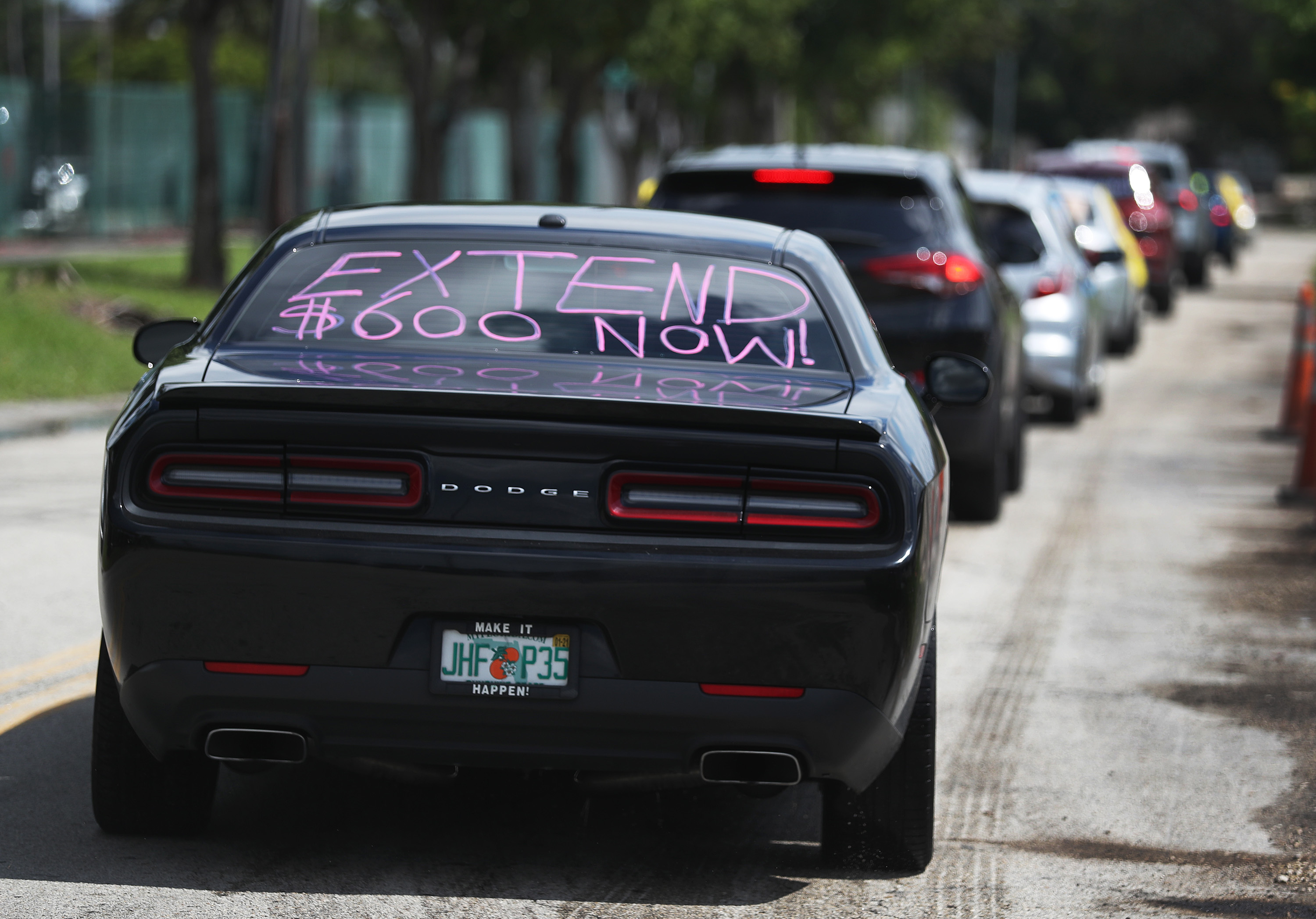 A car participates in a July 16, 2020 caravan protest headed for the Coral Gables, Florida, office of Sen. Rick Scott. Caravan participants asked Scott and other Senators to support extension of unemployment benefits for laid-off Americans. (Joe Raedle—Getty Images)