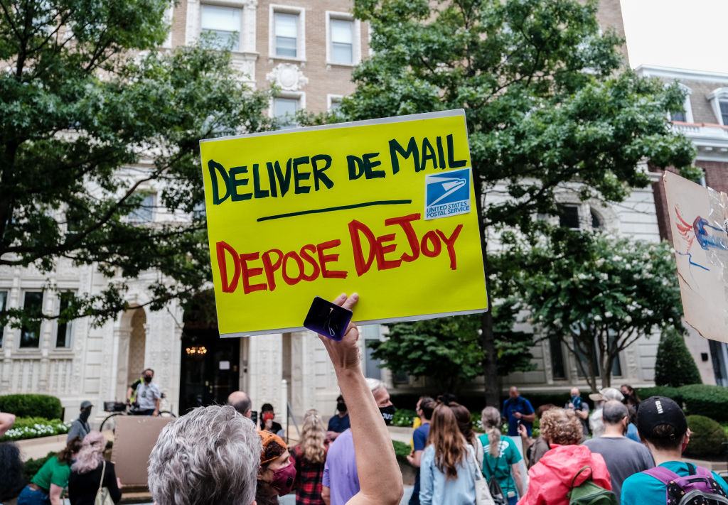 Demonstrators gather outside of the condo of President Donald Trump donor and current U.S. Postmaster General Louis Dejoy on August 15, 2020 in Washington, DC.