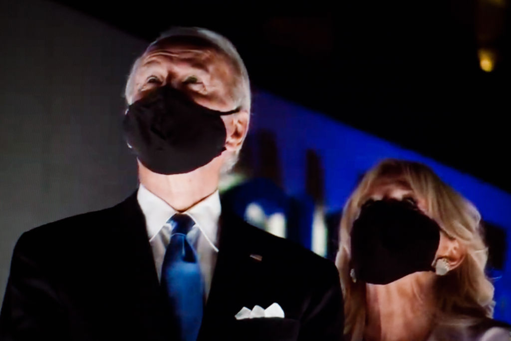 Presidential nominee and former US Vice President Joe Biden and wife Jill Biden wear face masks to watch a fireworks display during the closing moments of the virtual 2020 Democratic National Convention. (David Cliff—NurPhoto/Getty Images)