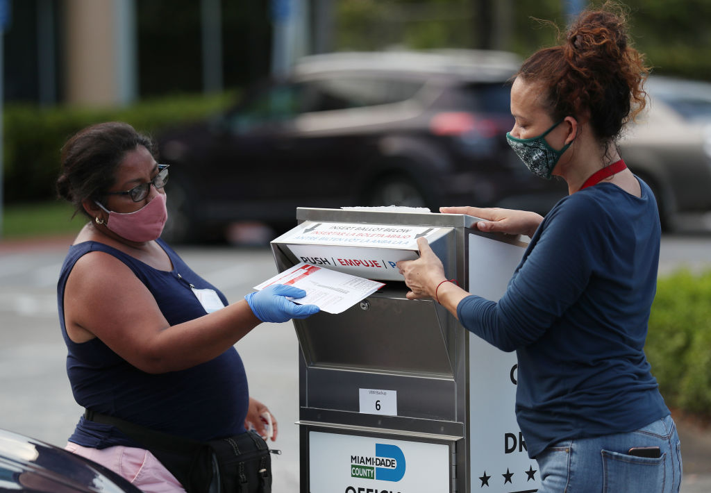 Poll workers at the Miami-Dade County Elections Department deposit peoples' mail in ballots into an official ballot drop box on primary election day on August 18. (Joe Raedle—Getty Images)