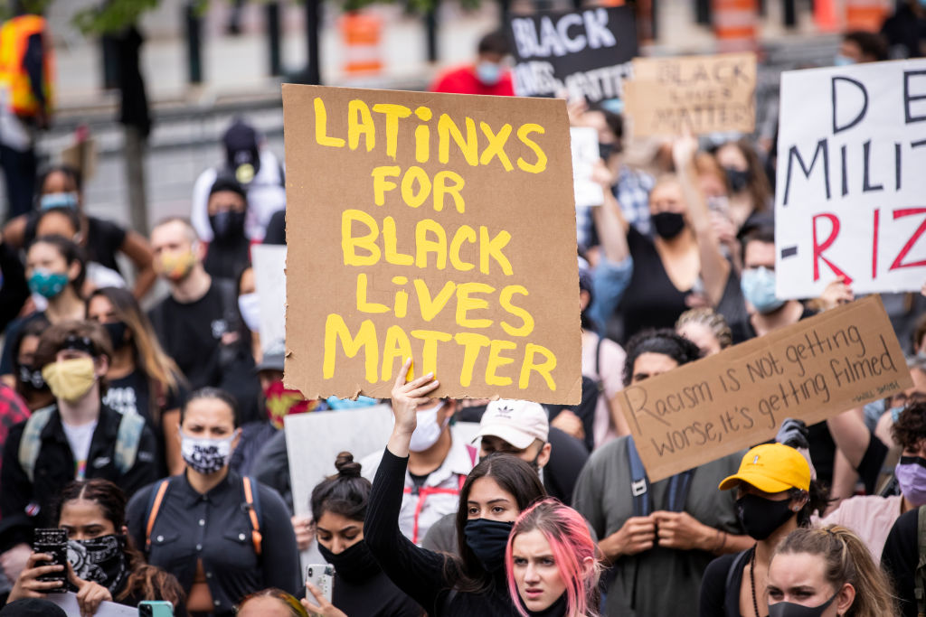 A  protester holds a sign that says, "Latinxs For Black Lives Matter" among the large crowd in Foley Square in New York City on June 02, 2020. (Photo by Ira L. Black/Corbis via Getty Images)