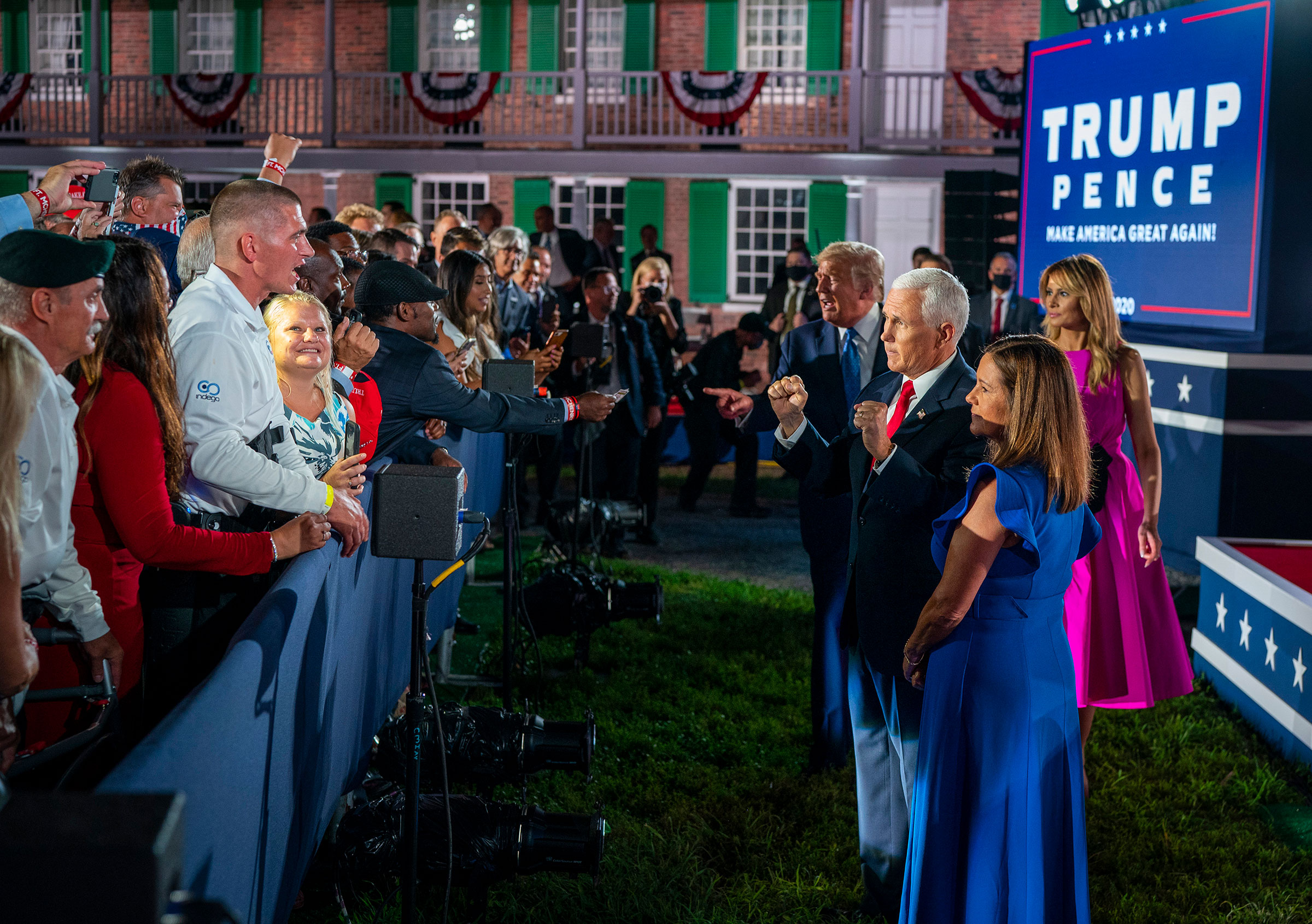 President Donald Trump and first lady Melania Trump, right behind, join Vice President Mike Pence and is wife, Karen Pence, while greeting attendees at Fort McHenry in Baltimore, during the Republican National Convention, on Wednesday, Aug. 26, 2020. (Dou