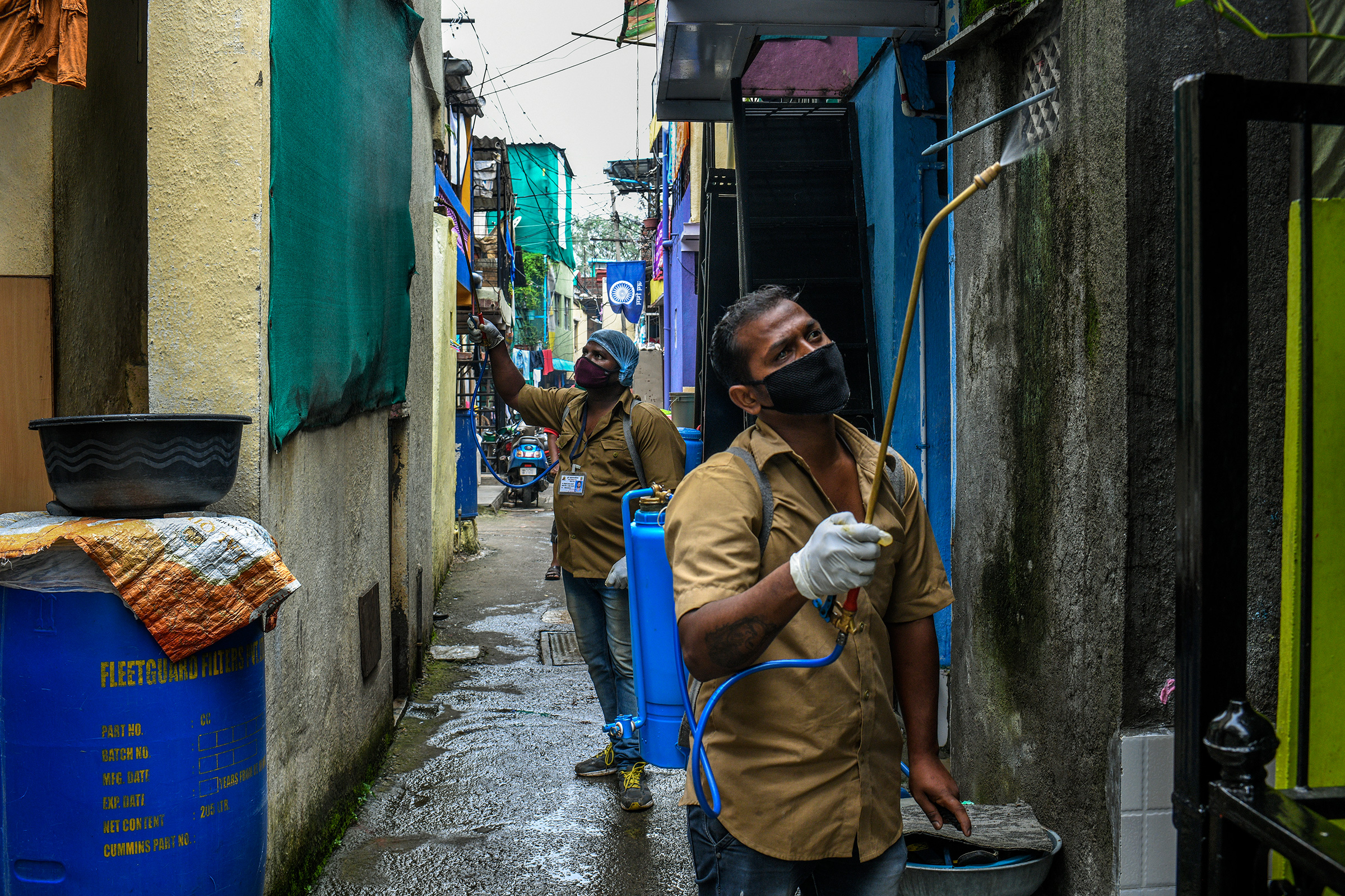 Trabajadores de desinfectantes en aerosol de la Corporación Municipal de Pune en el área de Tadiwala Chawl.