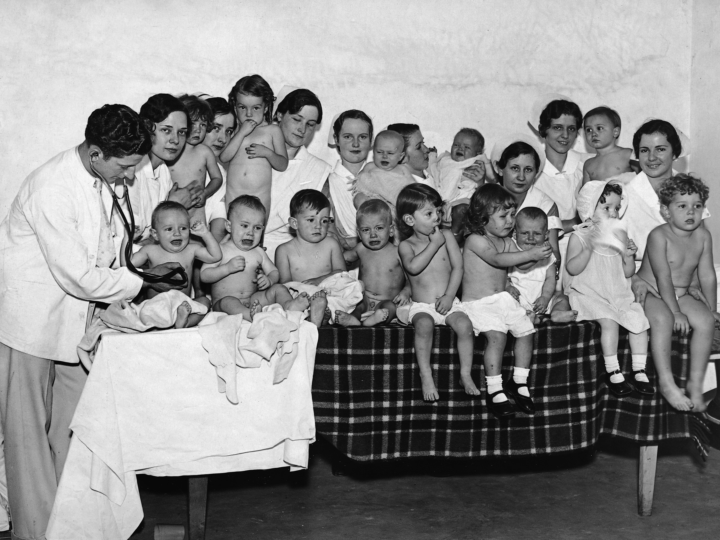 Dr. L. Sherman Examines Room Full of Babies