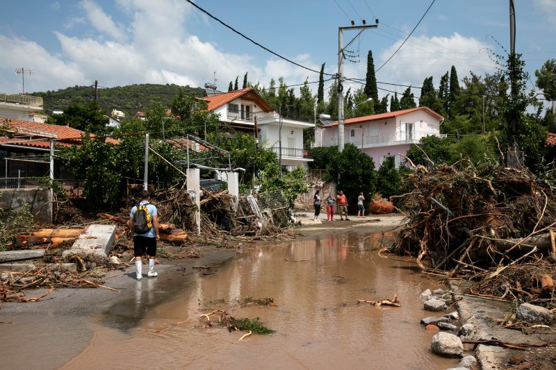 A man walks at a street full of debris following a storm at the village of Politika, on Evia island, northeast of Athens, on Aug. 9, 2020.