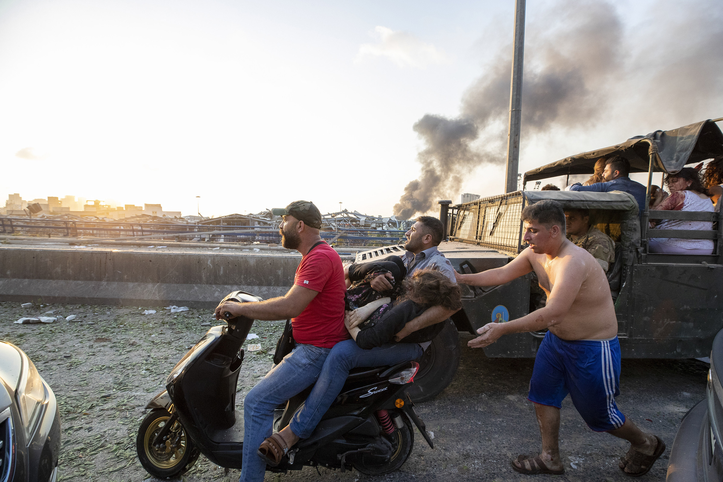 Wounded people evacuate after a massive explosion in Beirut. (Hassan Ammar—AP)