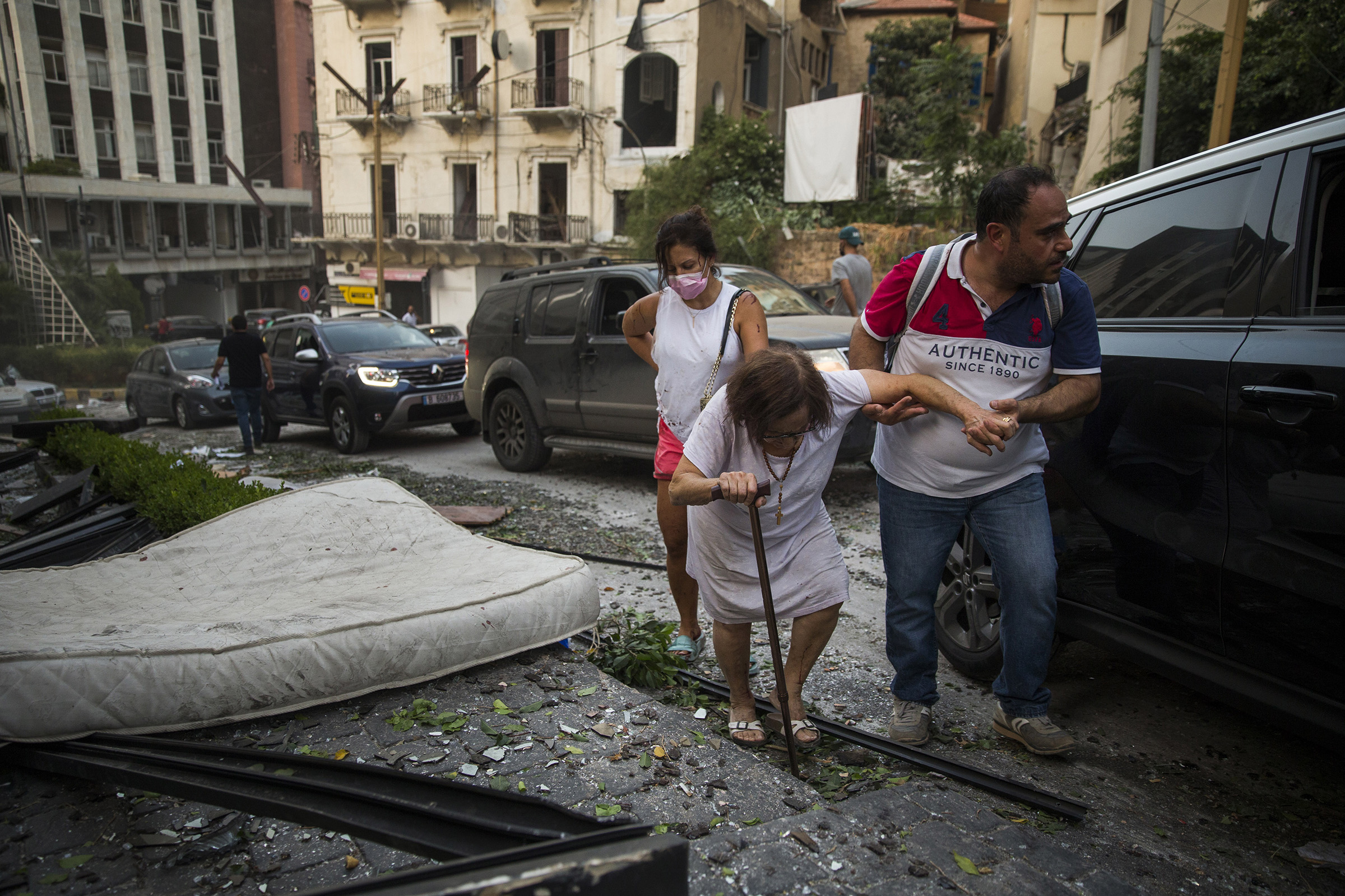 An elderly woman is helped while walking through debris after the explosion. (Daniel Carde—Getty Images)