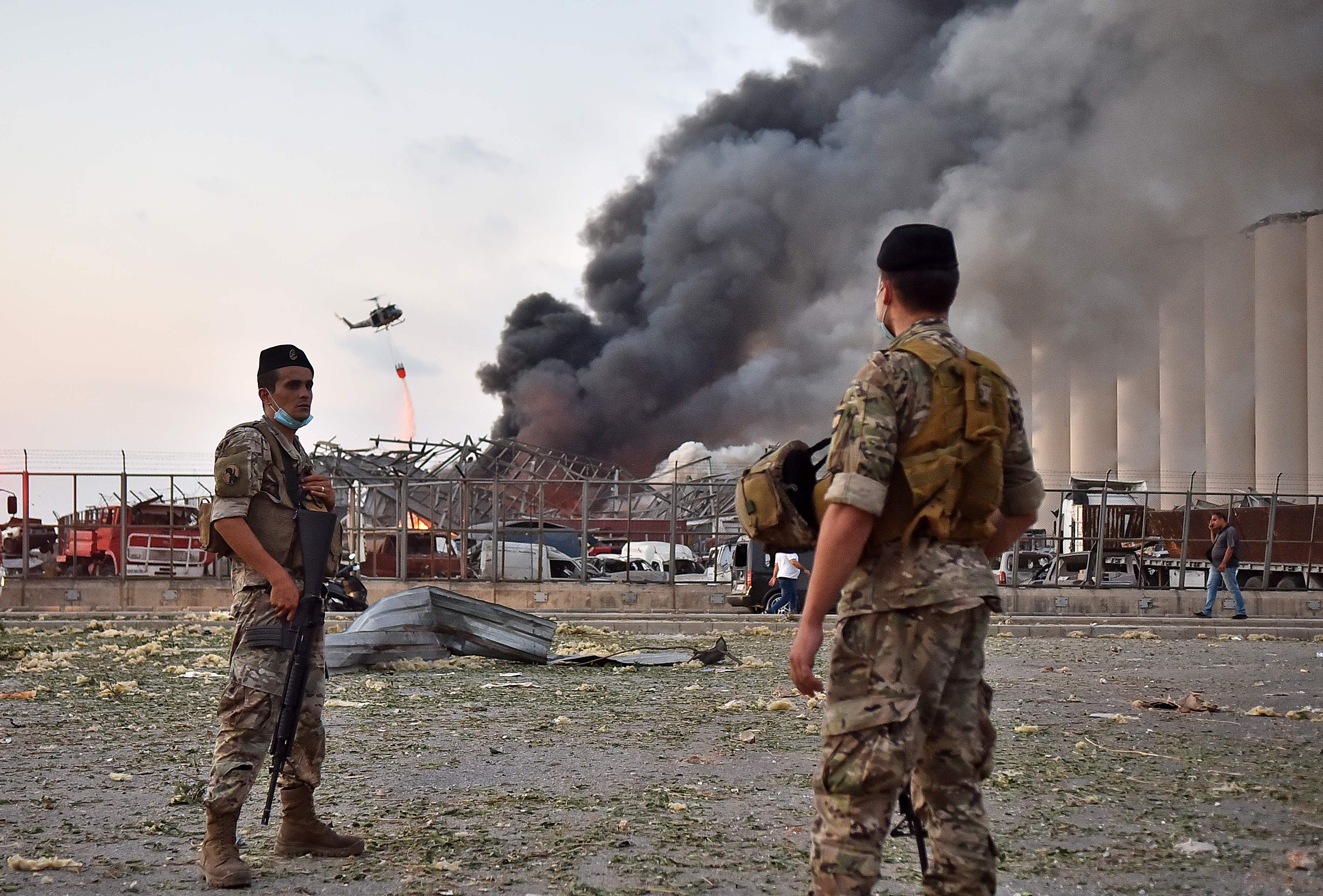 Lebanese army soldiers stand while a helicopter puts out a fire at the scene of the explosion. (AFP/Getty Images)