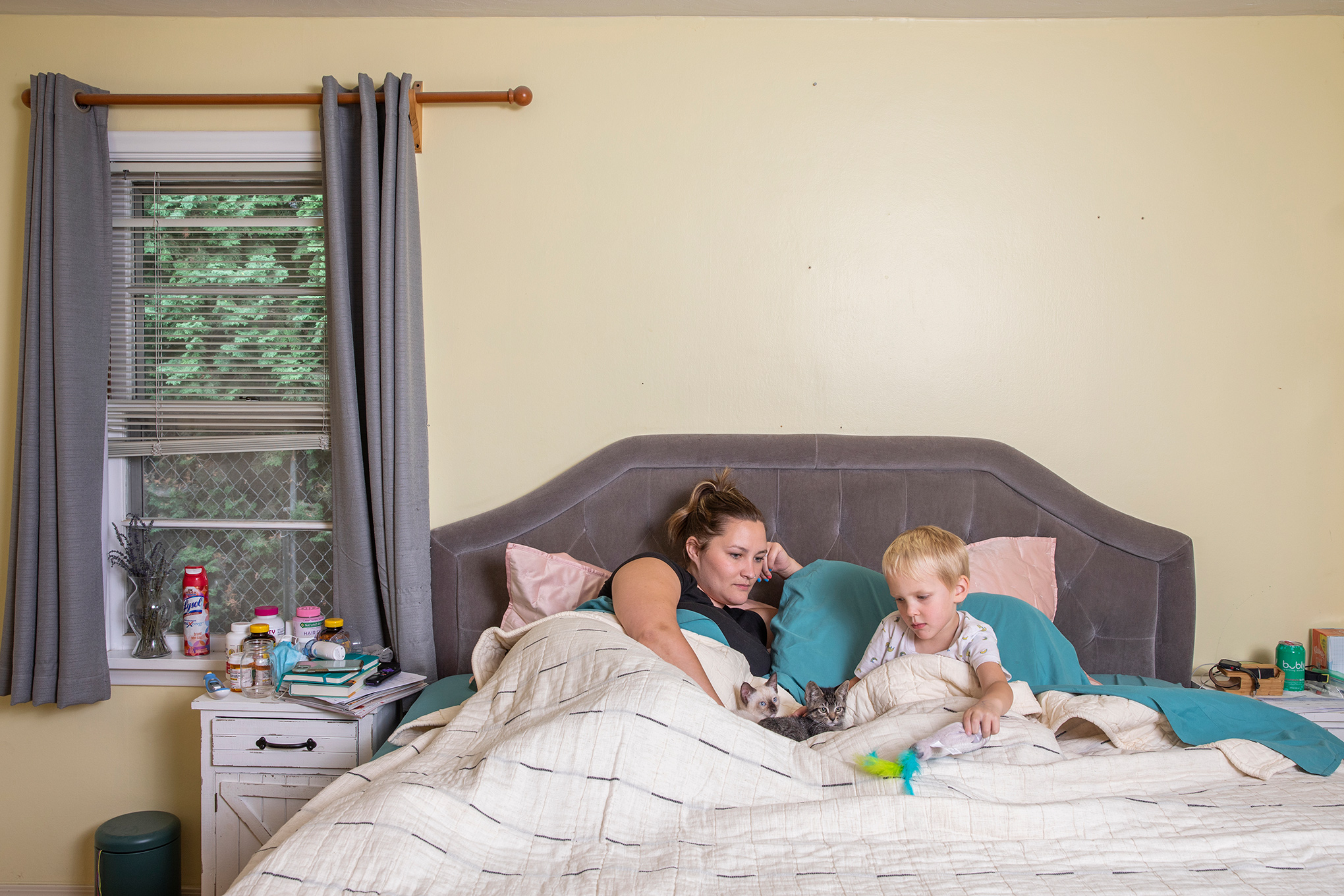 Kayla Brim and her son Titus, 4, at home in Caldwell, Idaho, on Aug. 11. With her energy sapped by long-term coronavirus symptoms, Brim spends much of her time in bed. (Angie Smith for TIME)