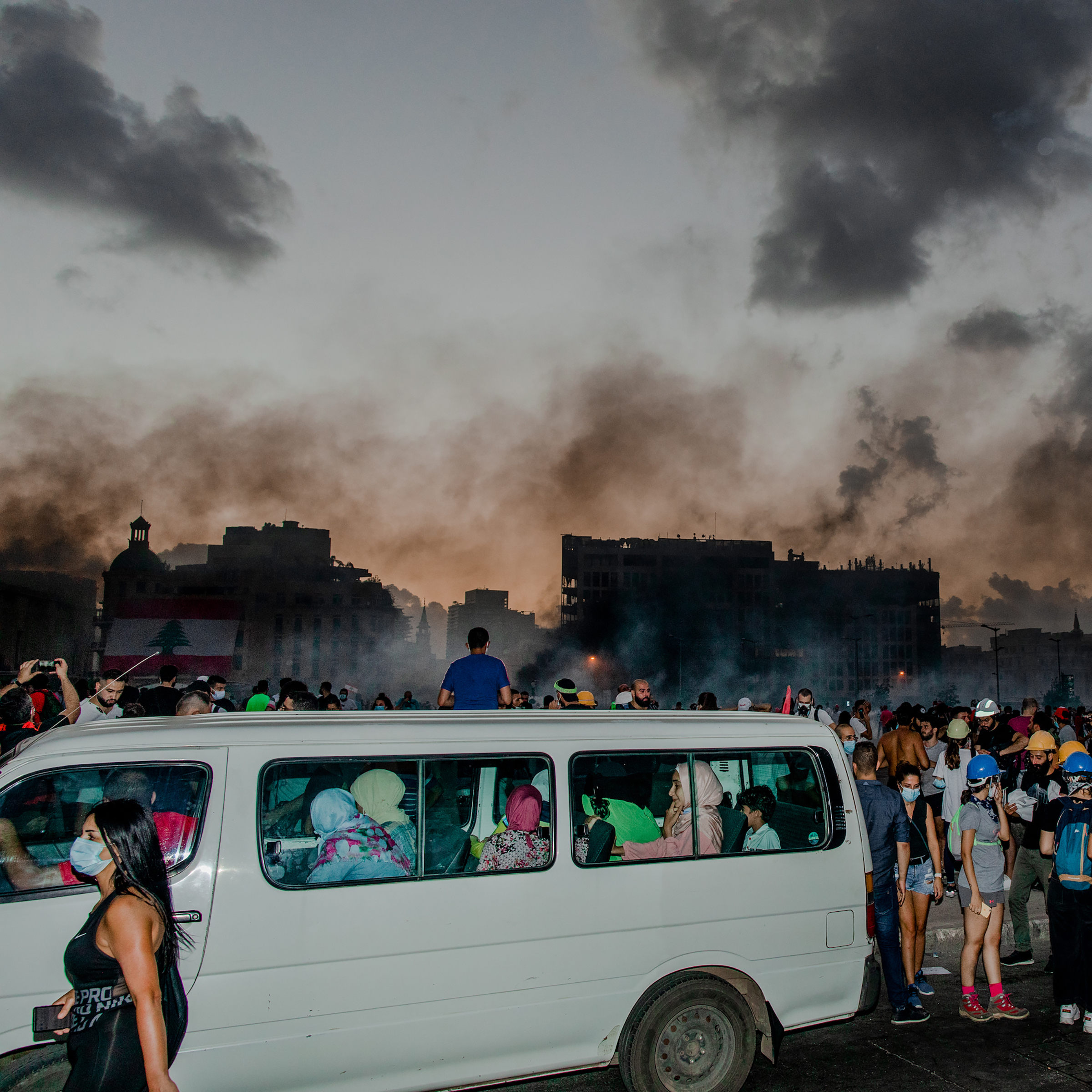 Un grupo de mujeres en una furgoneta evita espesas nubes de gas lacrimógeno en Beirut el 8 de agosto.