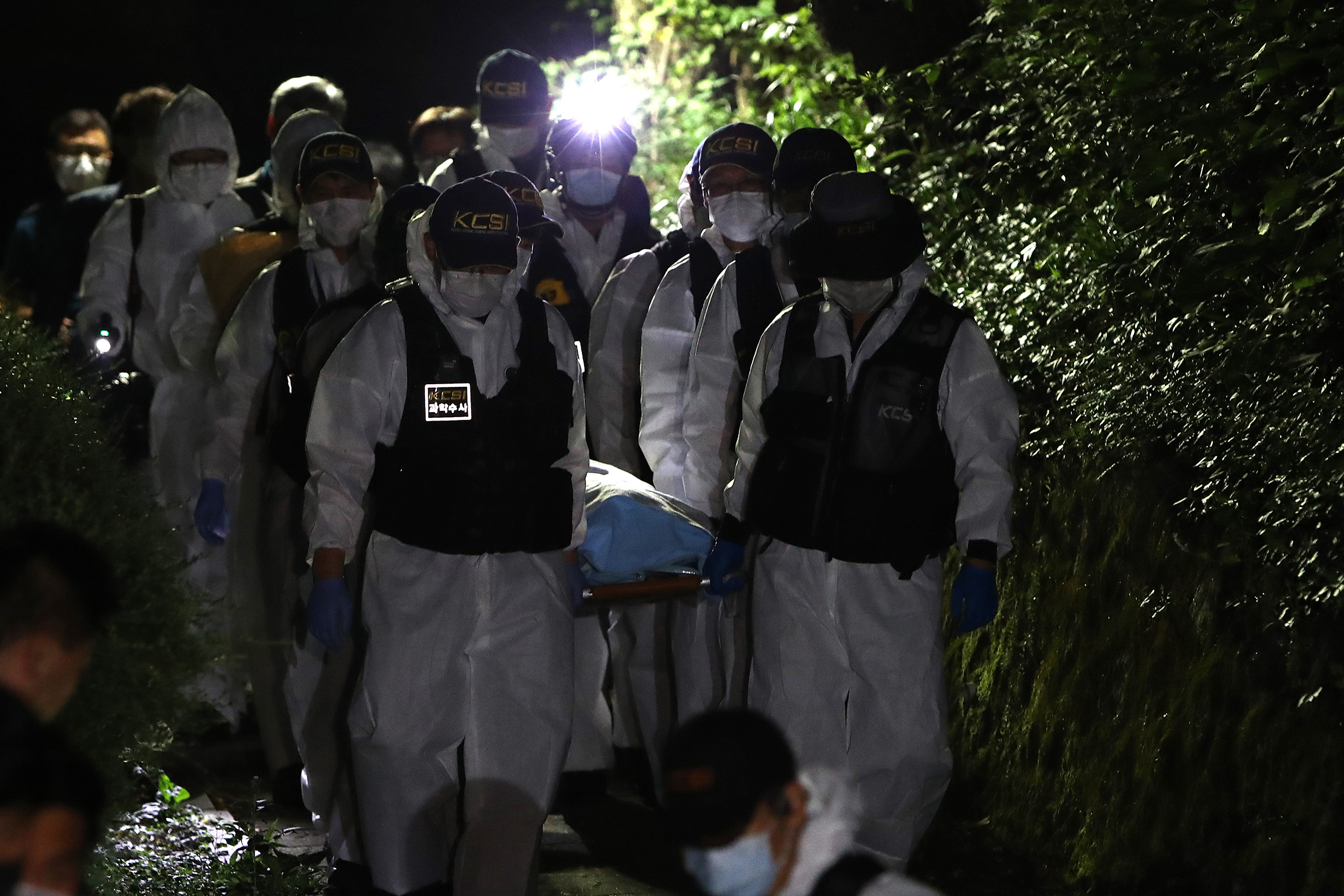 Police officers carry Park's body on July 10