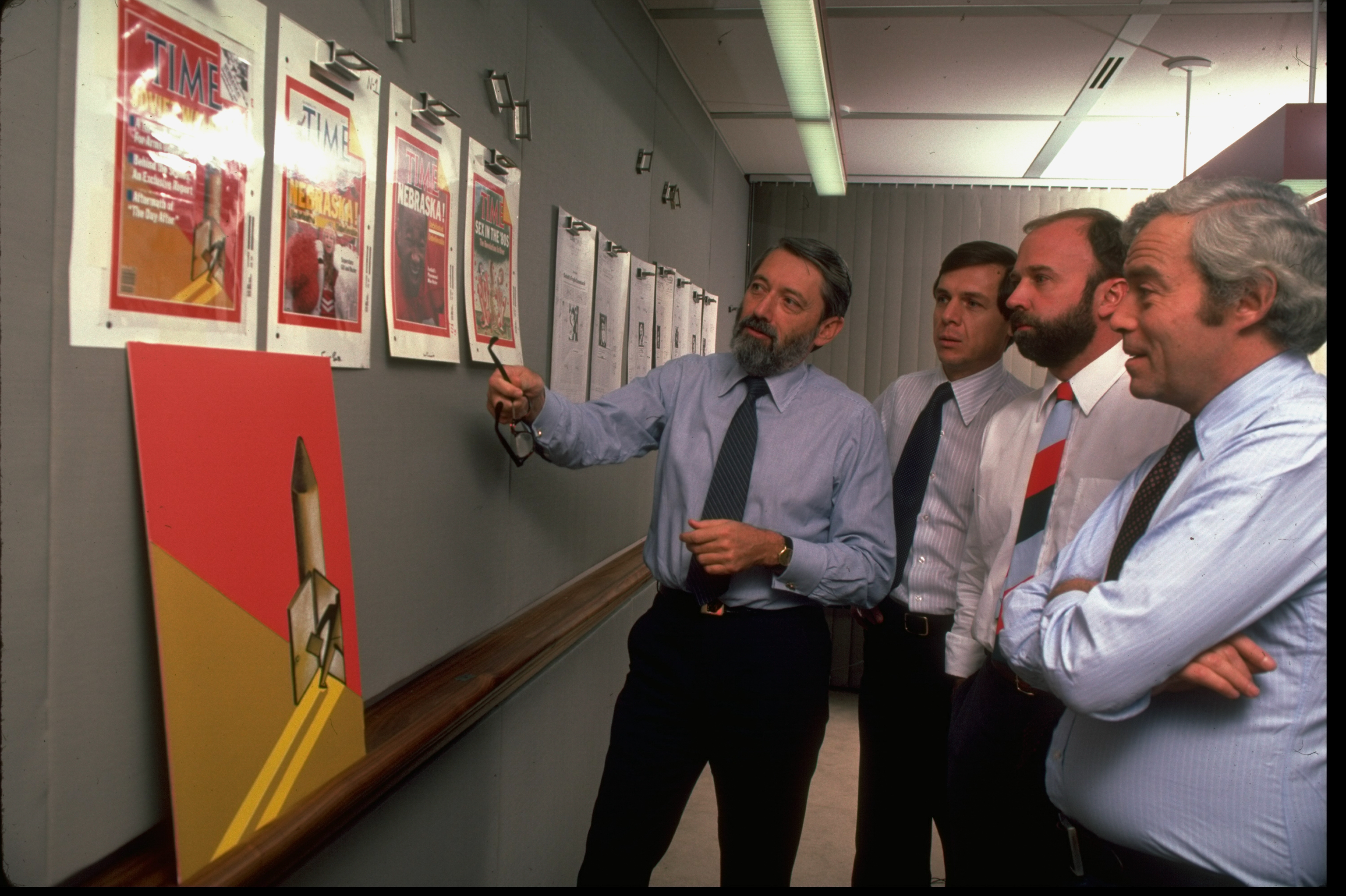 TIME magazine editor Ray Cave (L) examining cover ideas with other editors in 1983 (Henry Groskinsky—The LIFE Images Collection via Getty Images)