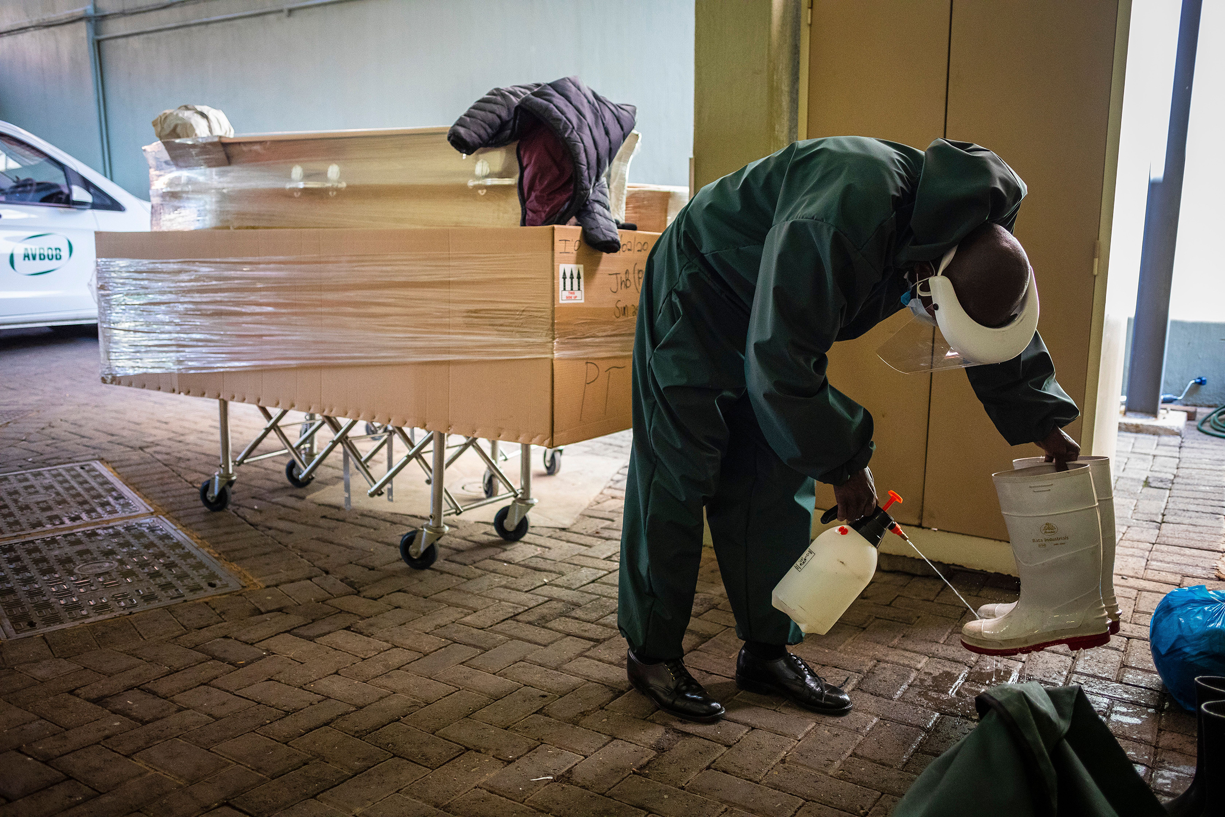 Undertaker Steven Ntuli sterilizes his boots after collecting a suspected Covid-19 victim from a government hospital in Johannesburg, South Africa, on 21 July 2020. (Kim Ludbrook—EPA-EFE/Shutterstock)