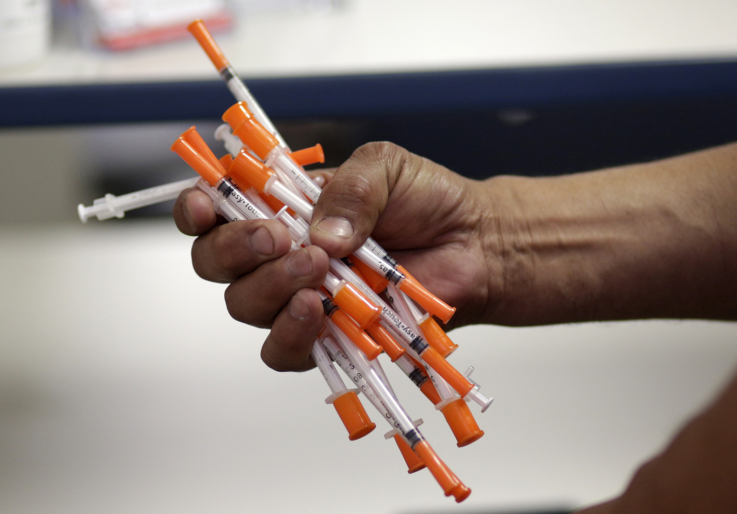 Jose Garcia, an injection drug user, deposits used needles into a container at the IDEA exchange, in Miami on May 6, 2019.
