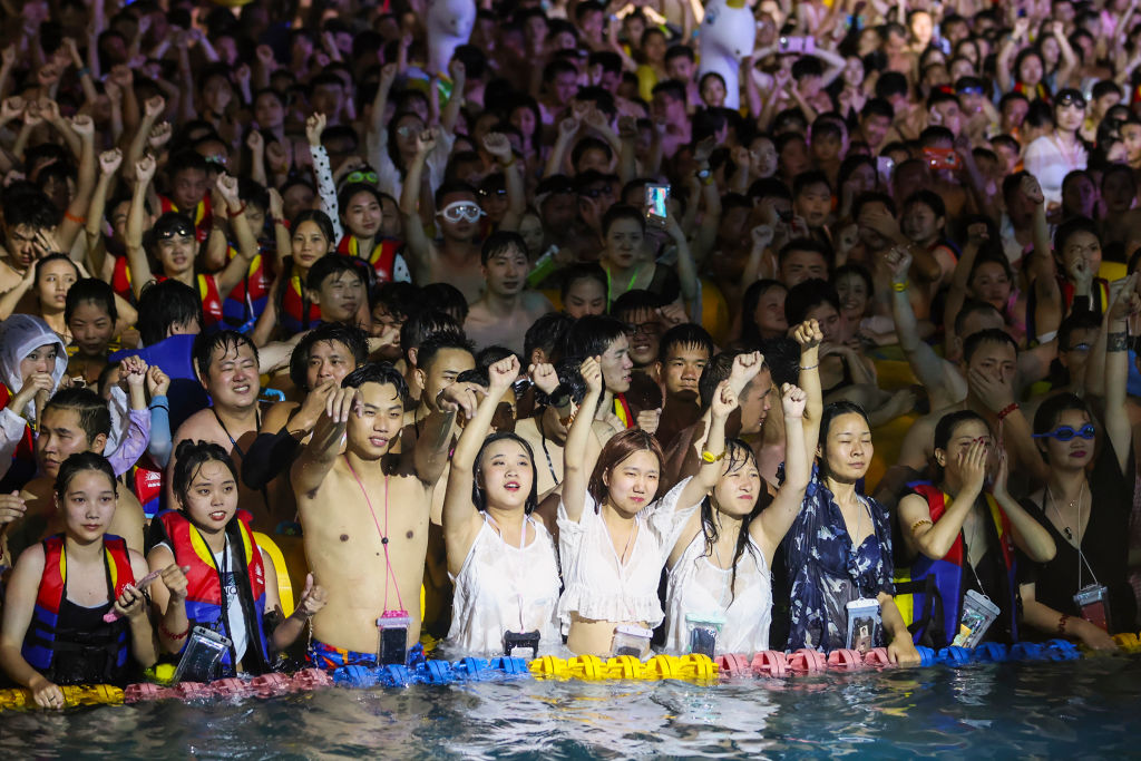 This photo, taken on August 15, 2020 shows people watching a performance as they cool off in a swimming pool in Wuhan in China's central Hubei province.