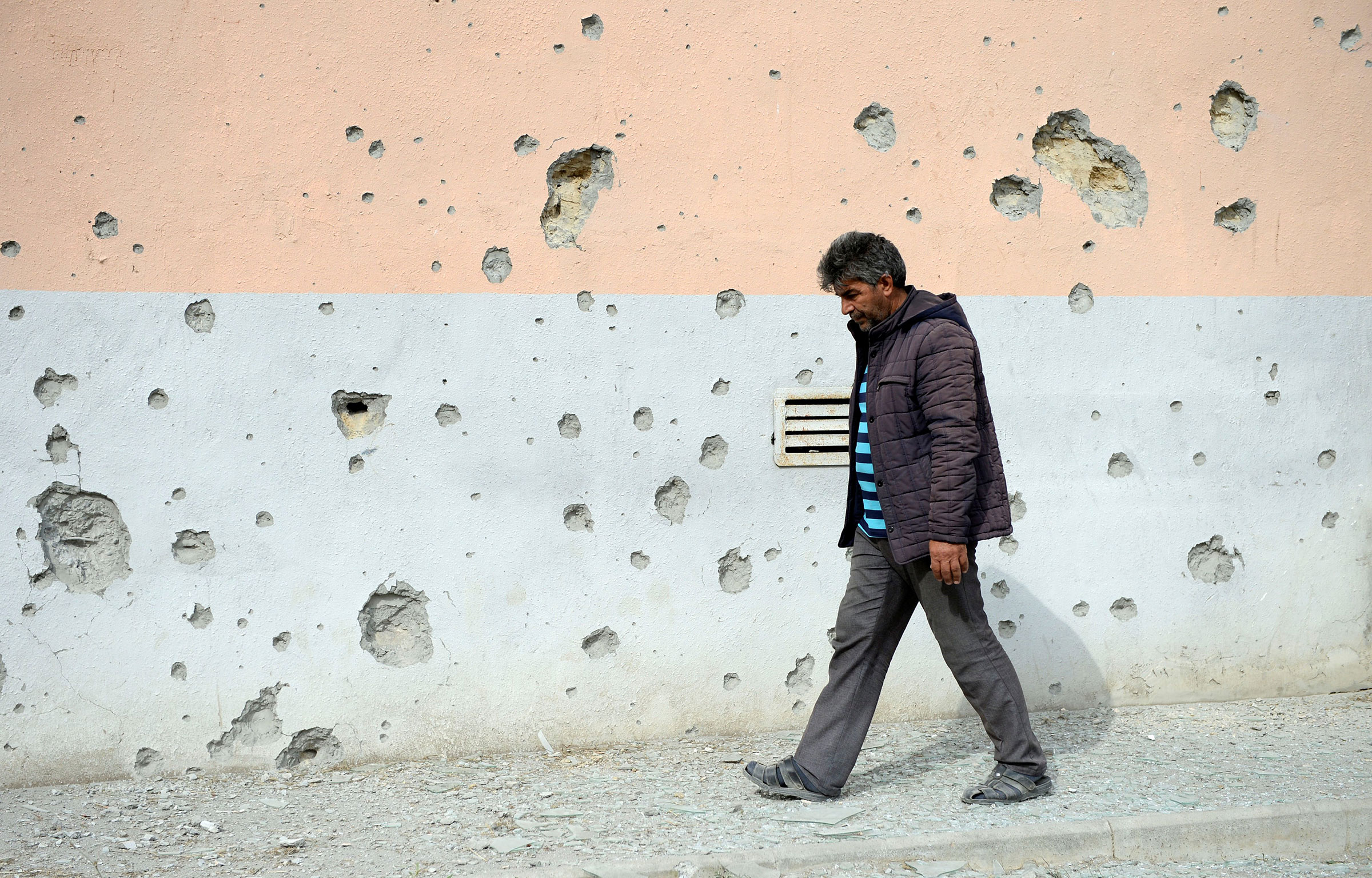 A man walks by a house that was damaged during clashes in the Tartar district bordering the Nagorno-Karabakh region, on Sept. 29, 2020. (Tofik Babayev—Xinhua/Getty Images)