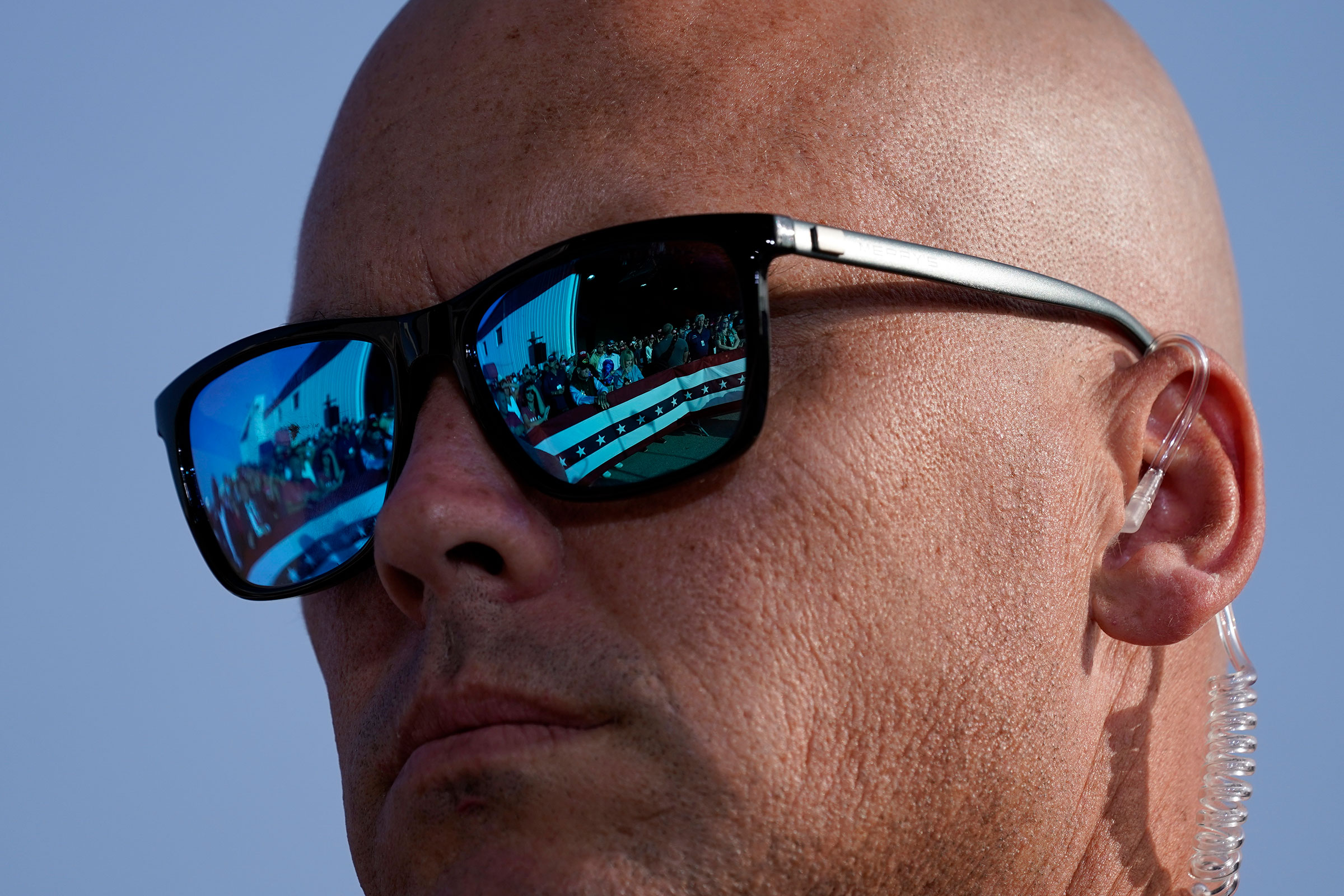 Supporters of President Donald Trump are reflected in the glasses of a U.S. Secret Service agent during a campaign rally at Dayton International Airport, Sept. 21, 2020. (Alex Brandon—AP)