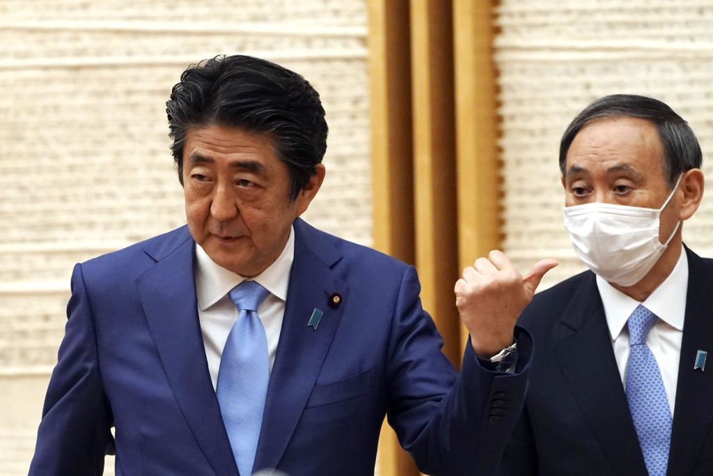 Japanese Prime Minister Shinzo Abe, left, gestures toward Chief Cabinet Secretary Yoshihide Suga during a news conference in Tokyo, Japan, on Monday, May 4, 2020. Suga is expected to succeed Abe, who is stepping down due to health problems. (Eugene Hoshiko–AP/Bloomberg/Getty Images)