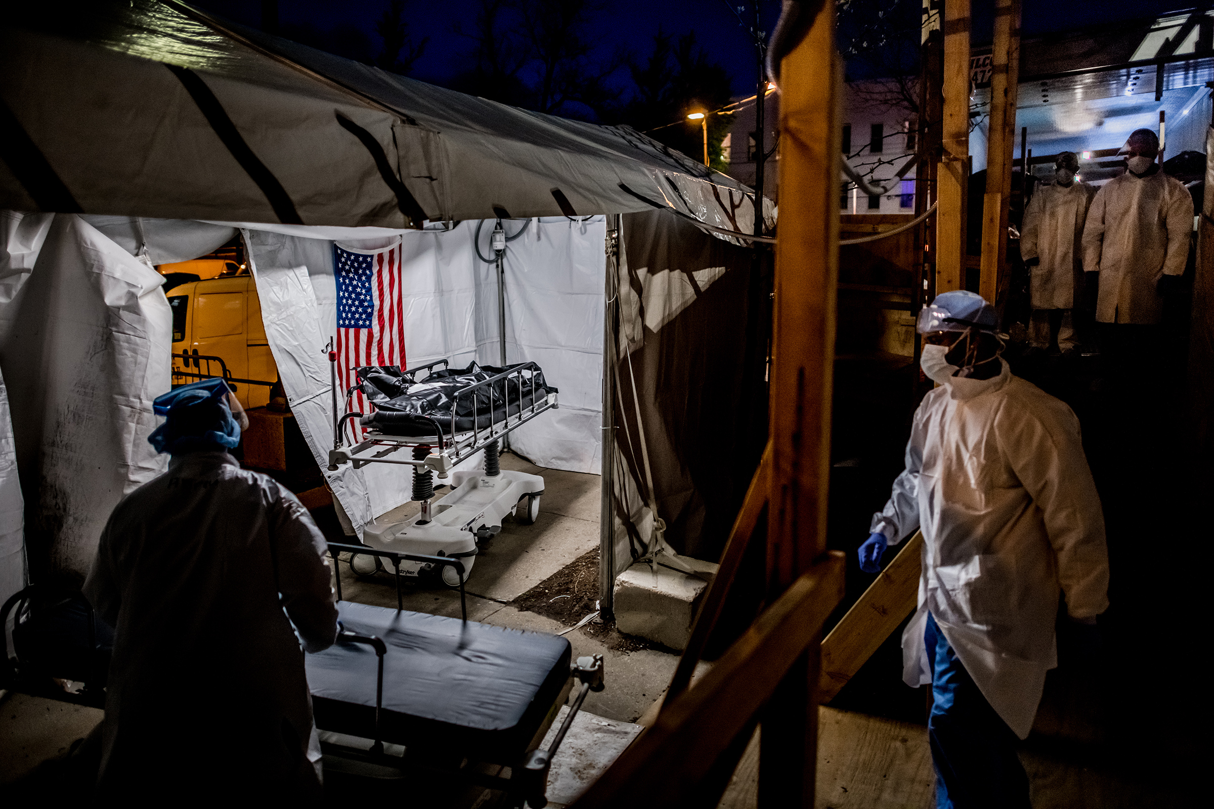 The transport team moves the body bags of deceased COVID-19 patients from the overflowing morgue of Brooklyn's Wyckoff Heights Medical Center into the improvised morgue set up outside on April 27. Three refrigerated semitrailers, capable of holding more than 150 bodies between them, were brought in as an emergency solution during the height of the pandemic. The transports often occurred at night to avoid upsetting neighbors of the hospital. (Meridith Kohut for TIME)