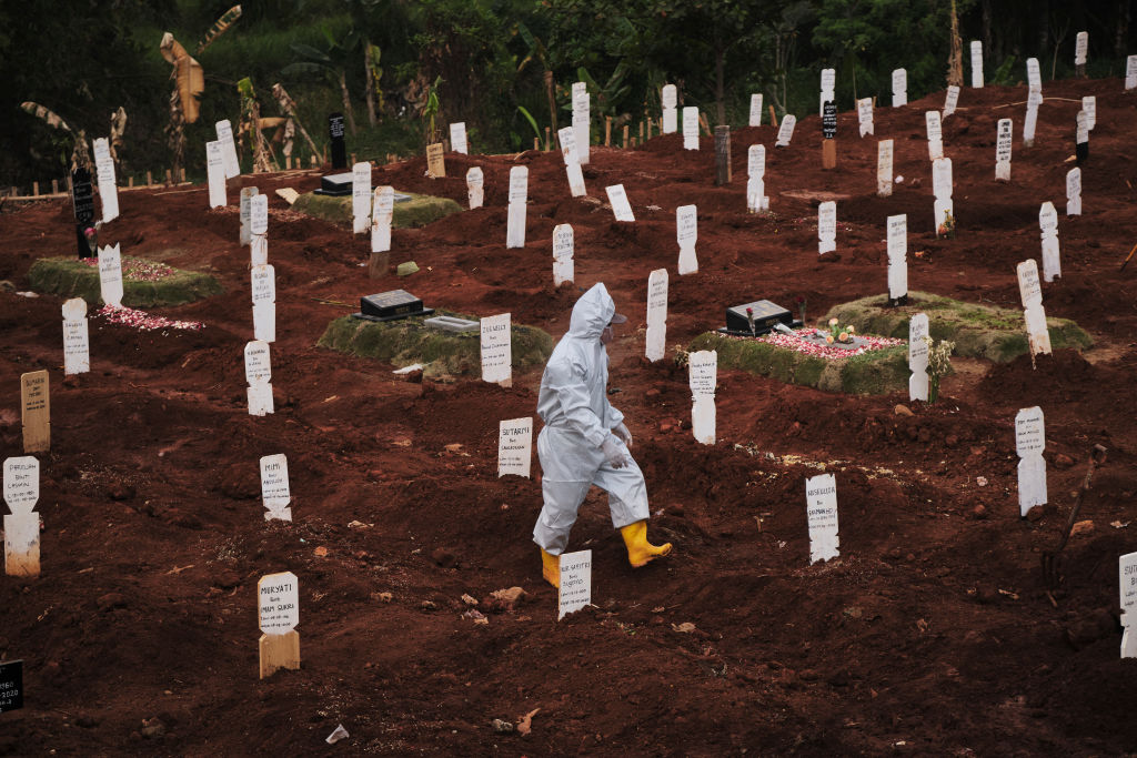 A municipal cemetery worker walks through a special cemetery for suspected Covid-19 victims on September 11, 2020 in Jakarta, Indonesia.