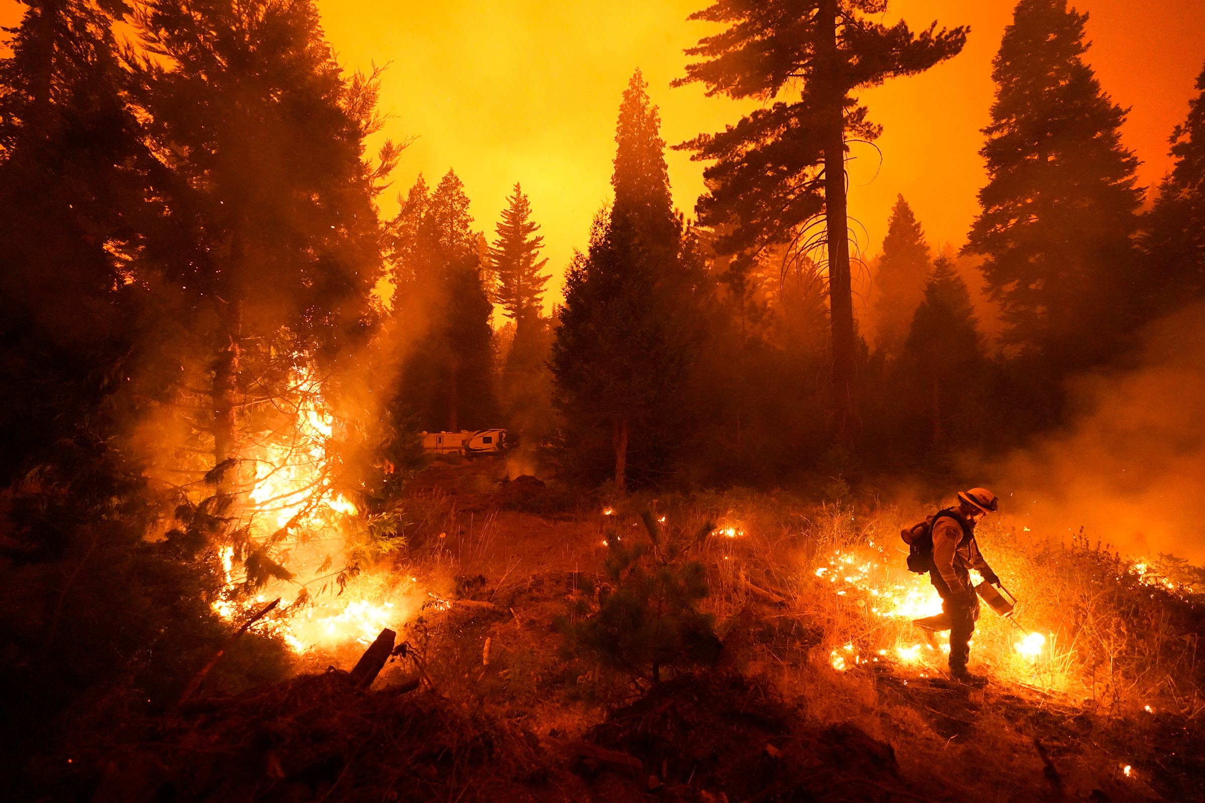 Firefighter Ricardo Gomez, part of a San Benito Monterey Cal Fire crew, sets a controlled burn with a drip torch while fighting the Creek Fire in Shaver Lake, Calif., on Sept. 6, 2020. (Marcio Jose Sanchez—AP.)