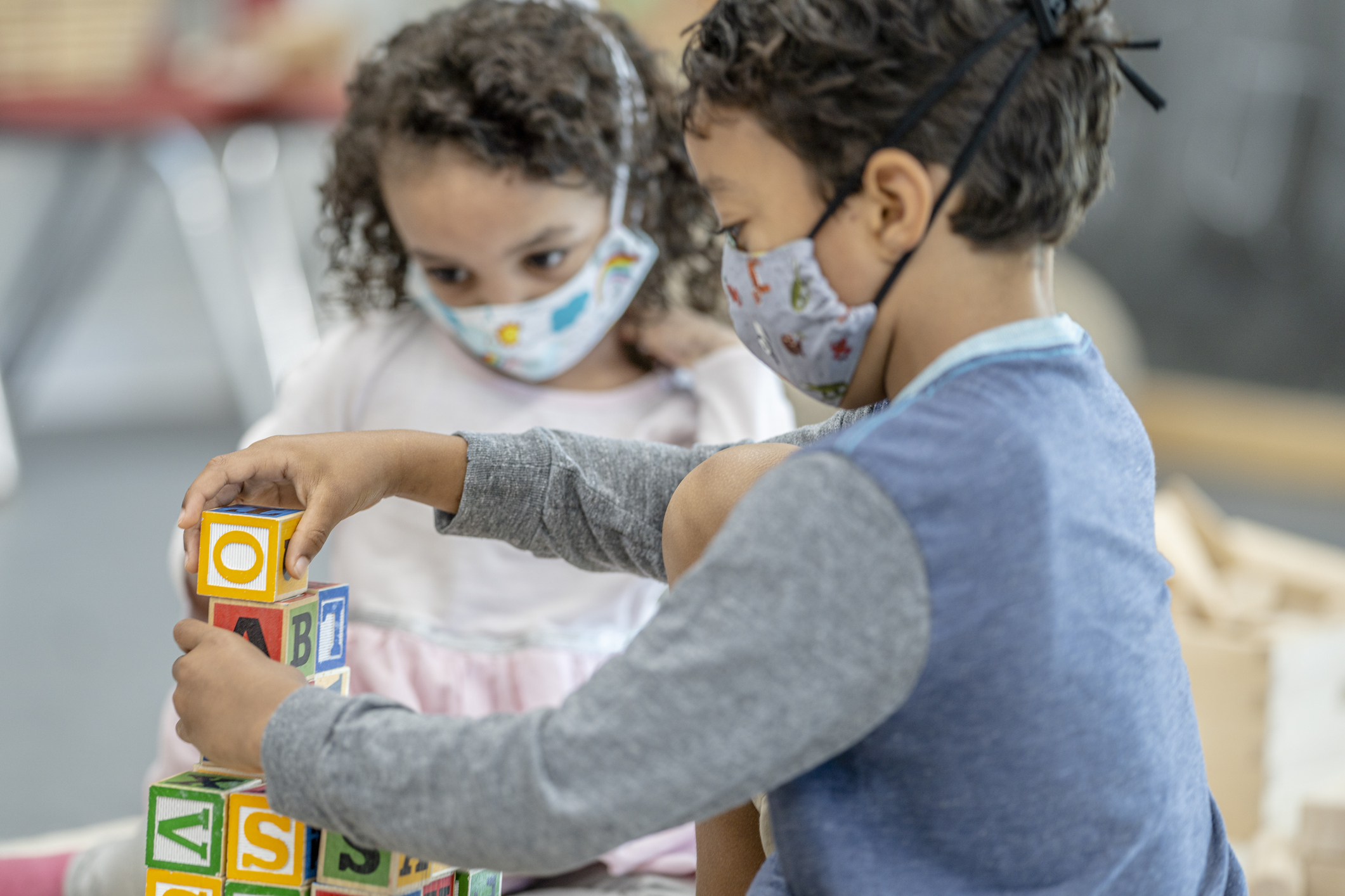 Children playing at daycare while wearing masks