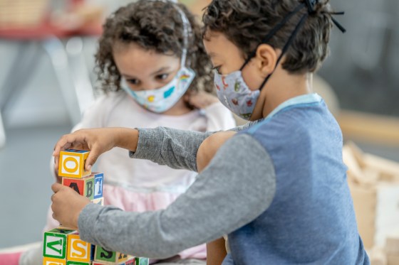 Children playing at daycare while wearing masks