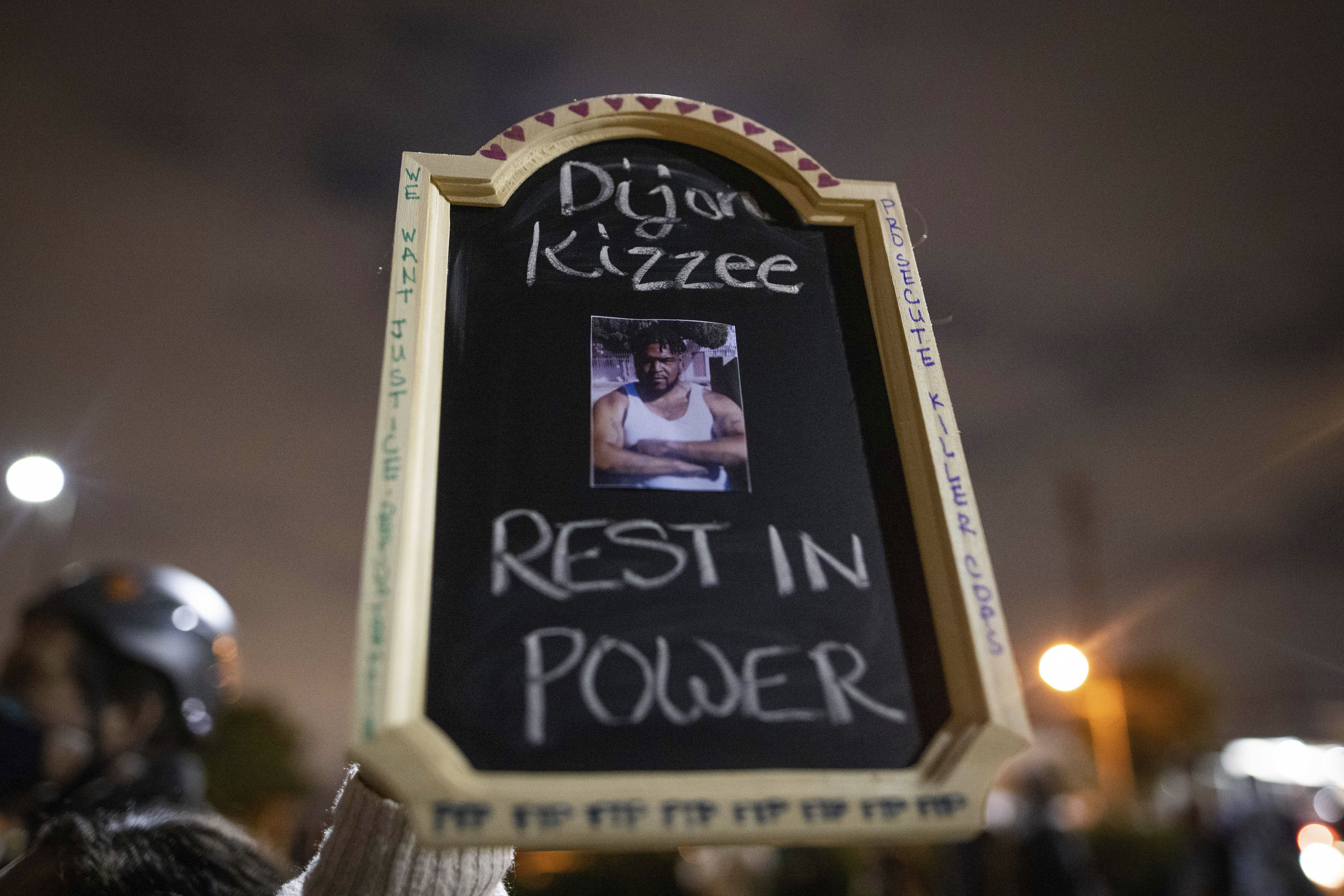 A protester holds a sign with a picture of Dijon Kizzee, who died after being shot by deputies of the Los Angeles Sheriff's Department on Aug. 31, 2020, in Los Angeles, Calif.