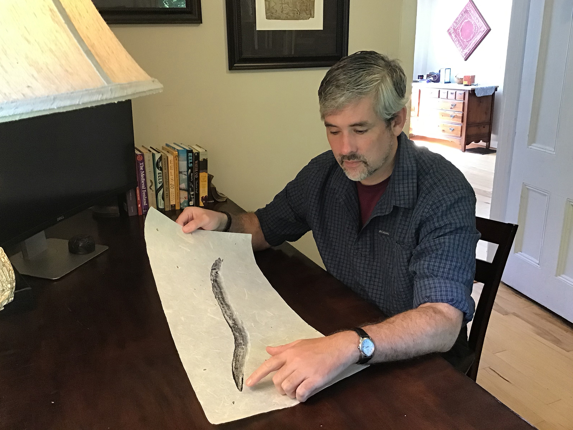 John Wyatt Greenlee looks at a gyotaku print of an eel by Bruce Koike in Sept. (Vanessa Greenlee)