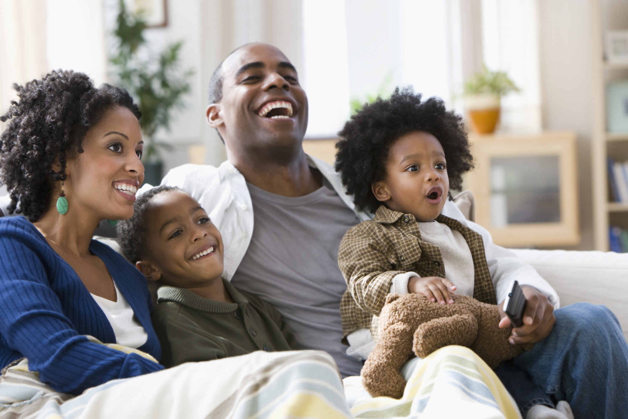 African American family watching television together