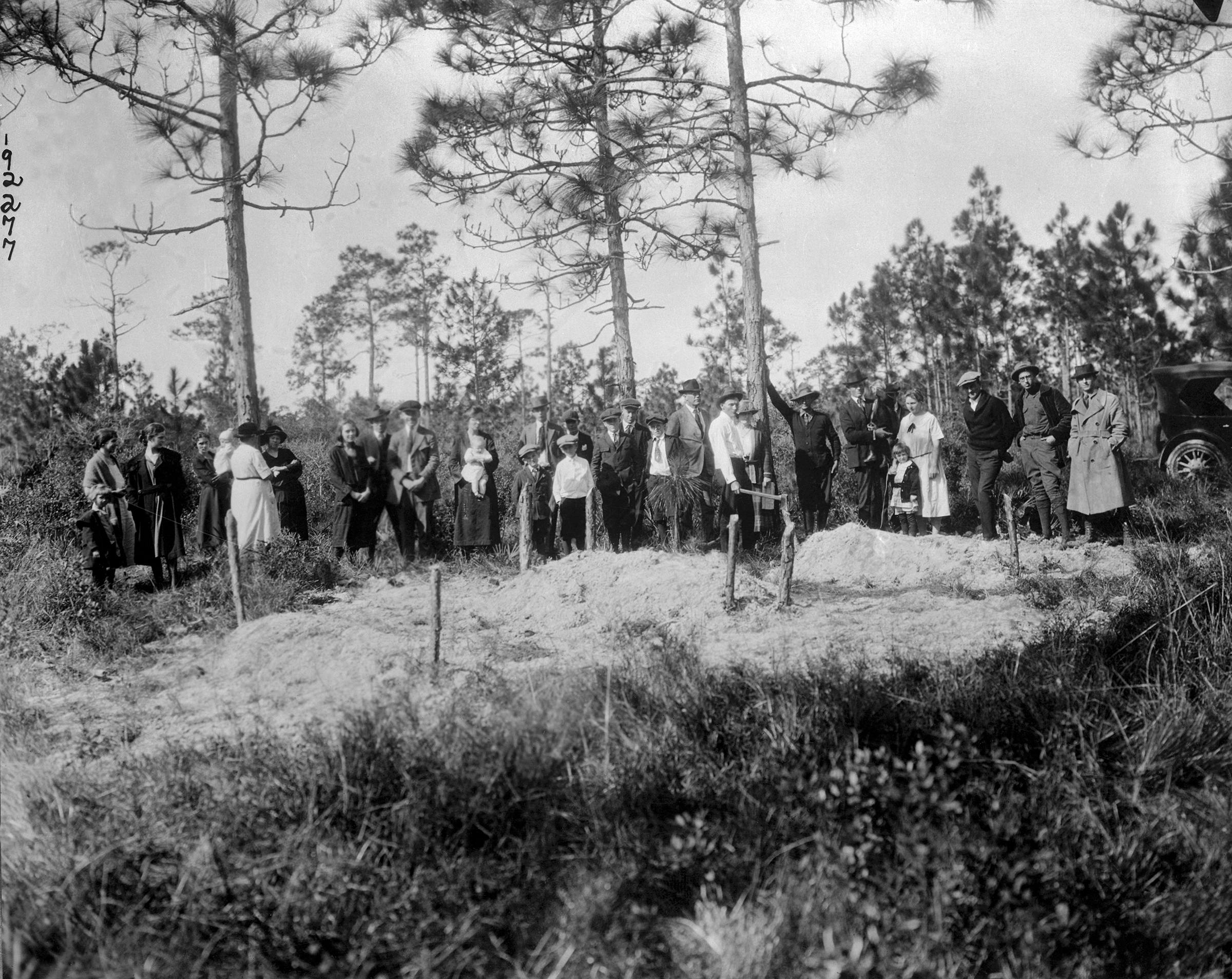 White residents of Sumner stand near three graves of six Black victims who were killed in Rosewood. (Bettmann Archive/Getty Images)