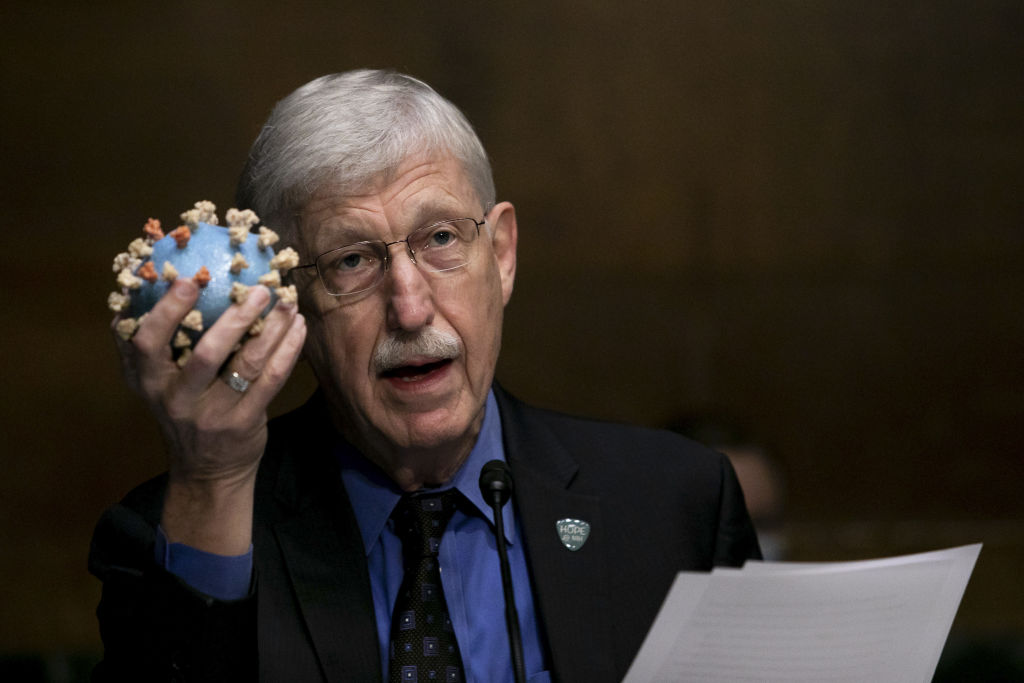 Francis Collins, director of the U.S. National Institutes of Health, holds a model of the COVID-19 virus while speaking during a Senate hearing titled 