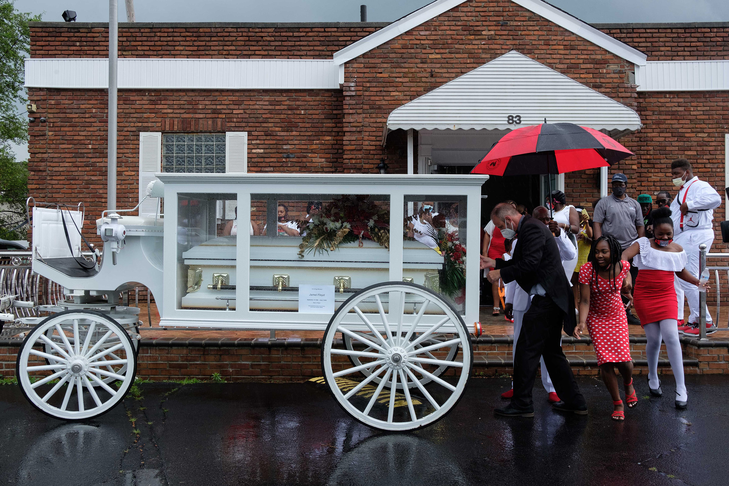 Jamel Floyd’s coffin is placed in a horse carriage after the funeral.