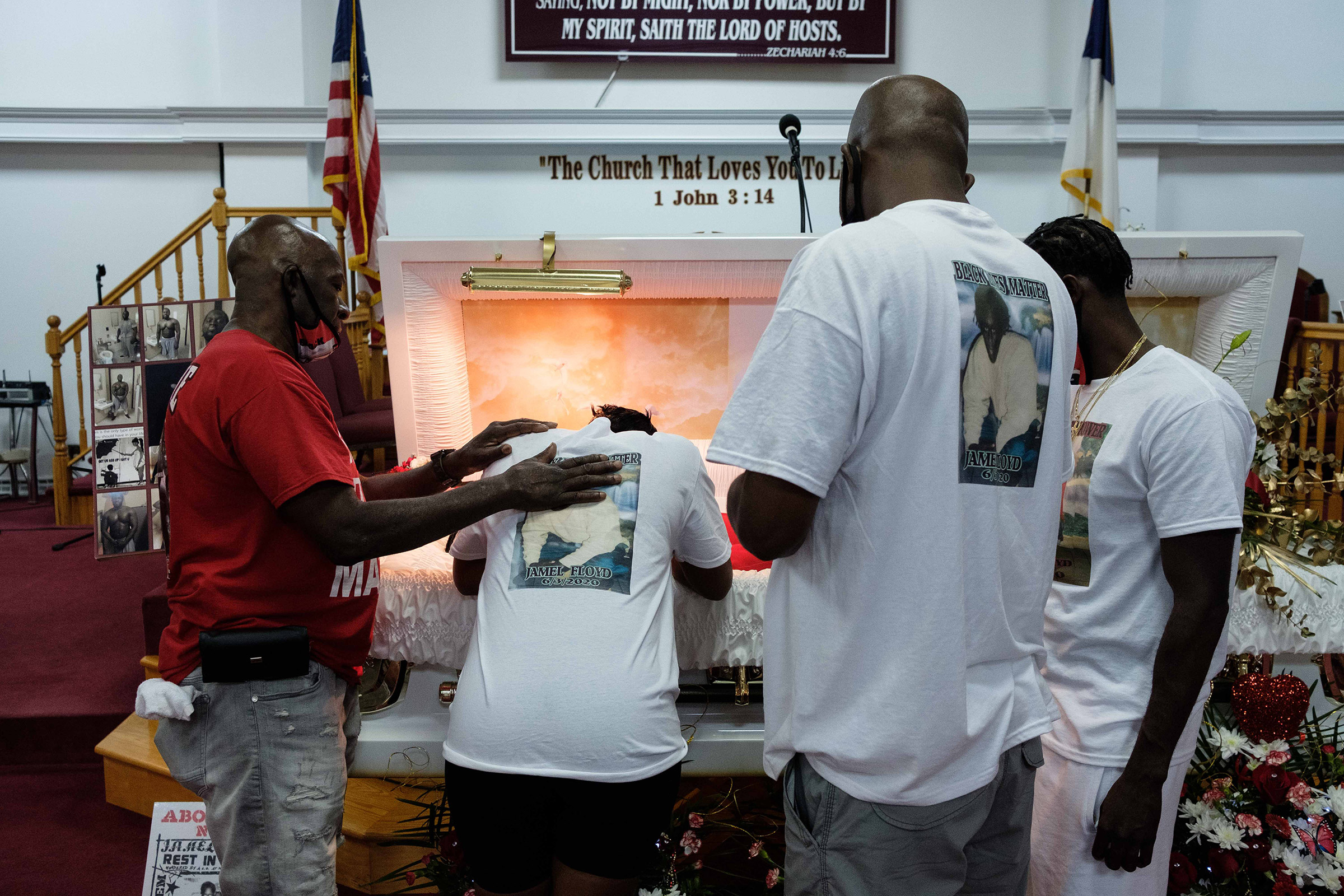 Ramel Floyd looks down at his older brother's body during the wake on June 29.