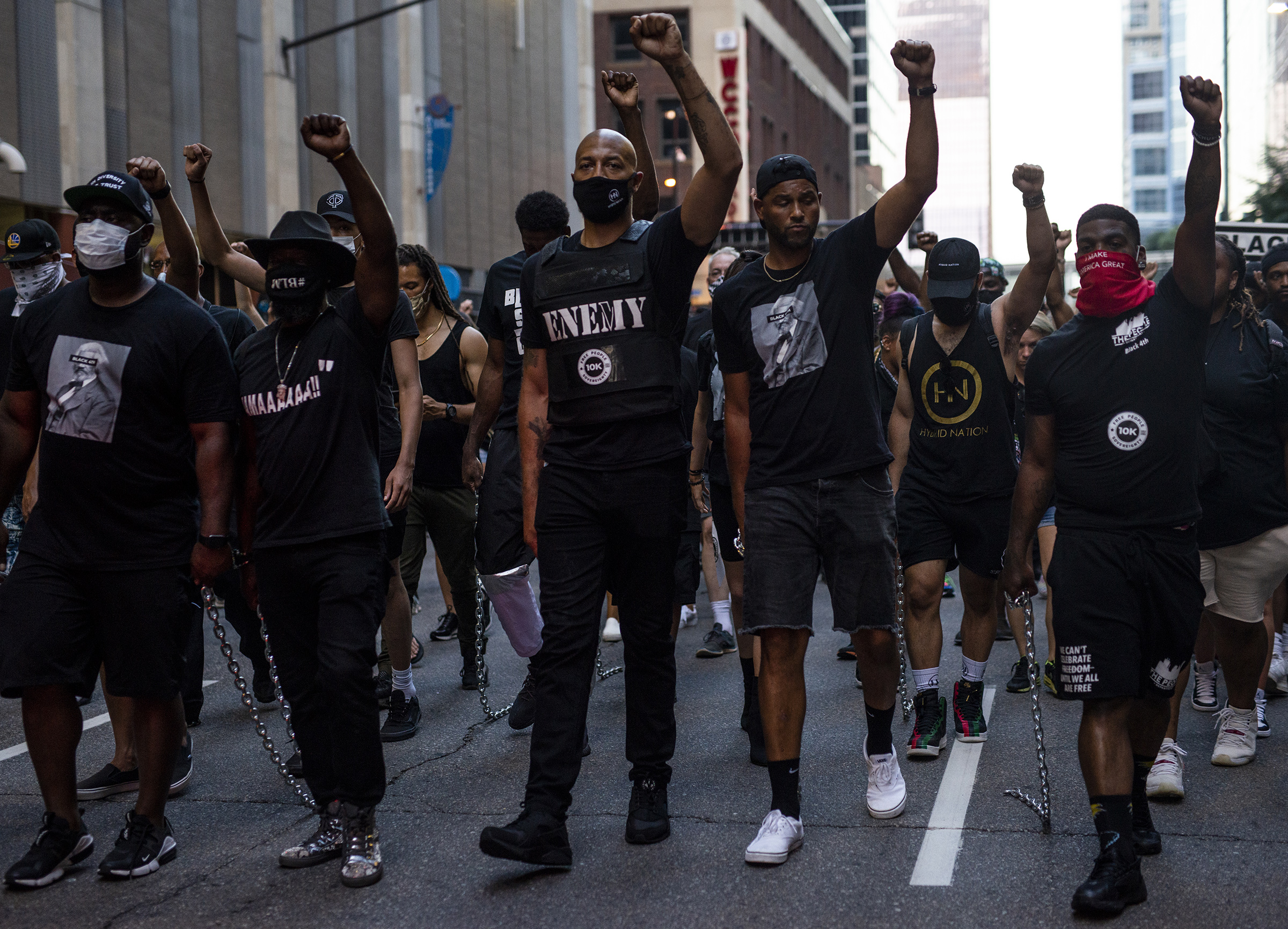 Royce White, center, and demonstrators drag chains behind them during the Black 4th protest in downtown Minneapolis on July 4 (Stephen Maturen—Getty Images)