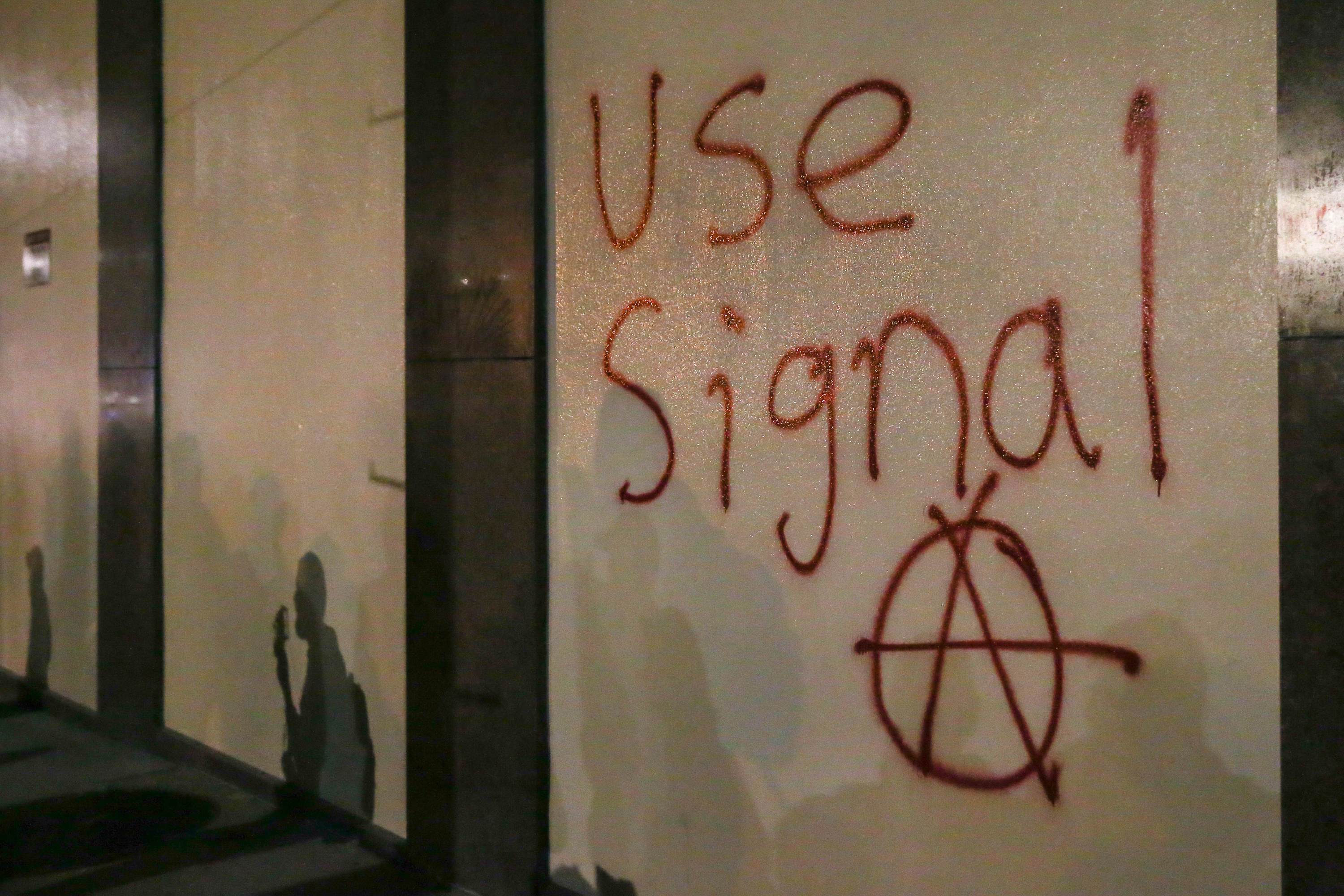 Grafitti urging people to use Signal is spray-painted on a wall during a protest on February 1, 2017 at UC Berkeley, California.