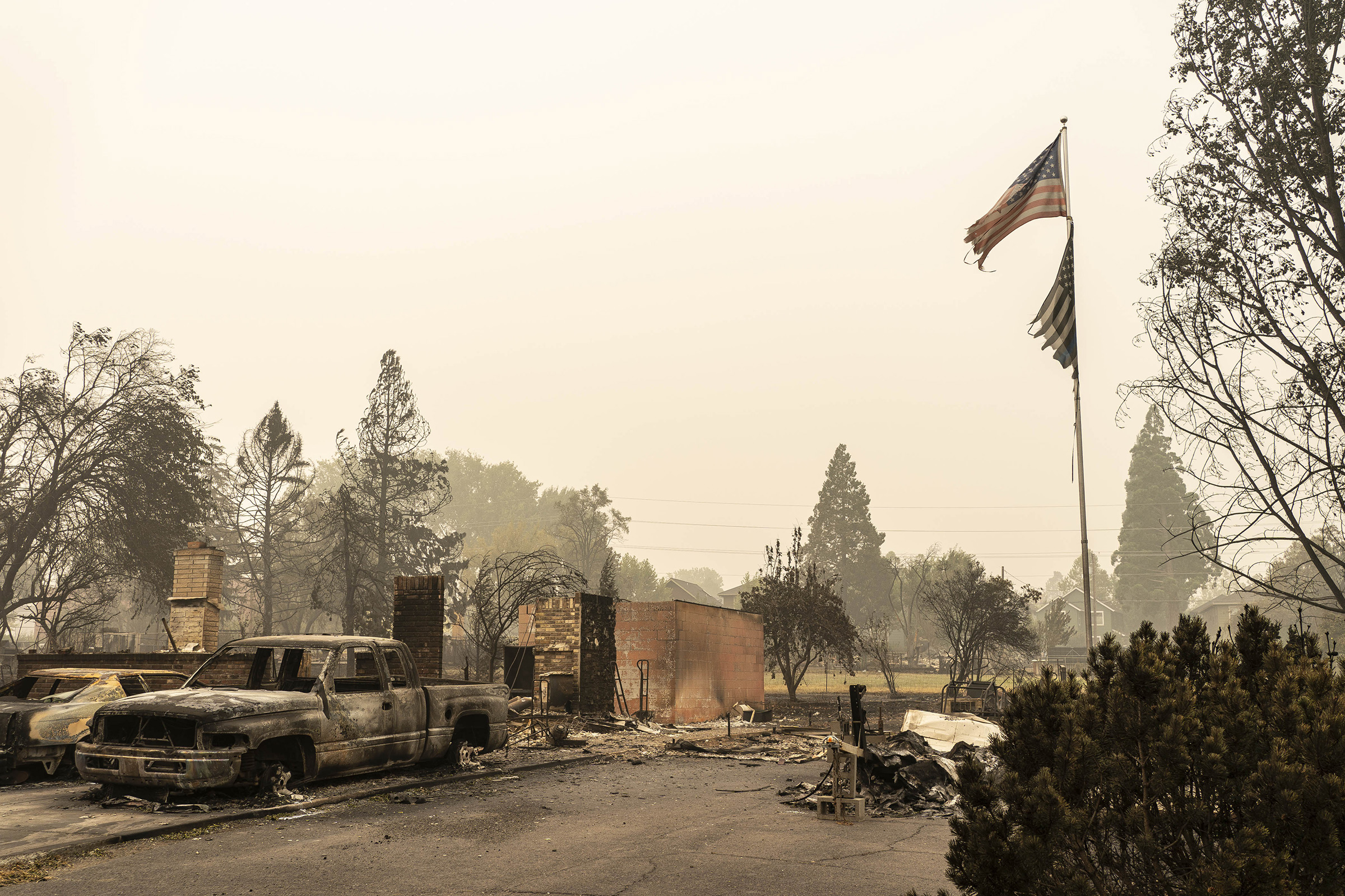 A U.S. flag flies at a burnt home in a neighborhood destroyed by wildfire on Sept. 13 in Talent, OR (David Ryder—Getty Images)