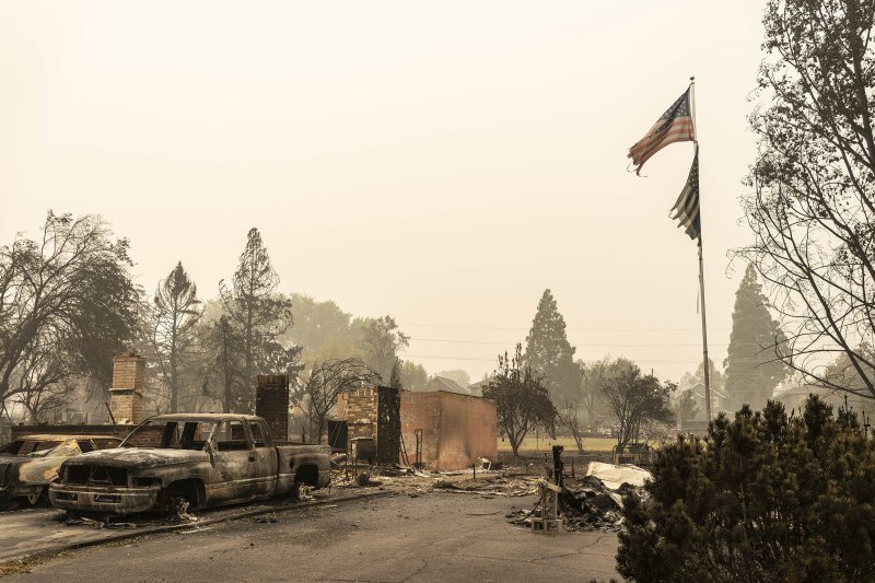 A U.S. flag flies at a burnt home in a neighborhood destroyed by wildfire on Sept. 13 in Talent, OR