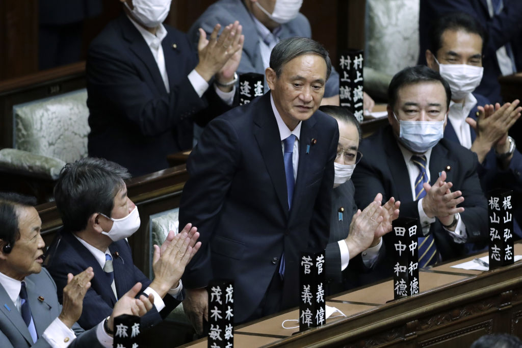 Yoshihide Suga, president of the Liberal Democratic Party (LDP), middle, receives a round of applause after being elected as Japan's prime minister during an extraordinary session at the lower house of parliament in Tokyo, Japan, on Sept. 16, 2020. (Kiyoshi Ota—Bloomberg/Getty Images)