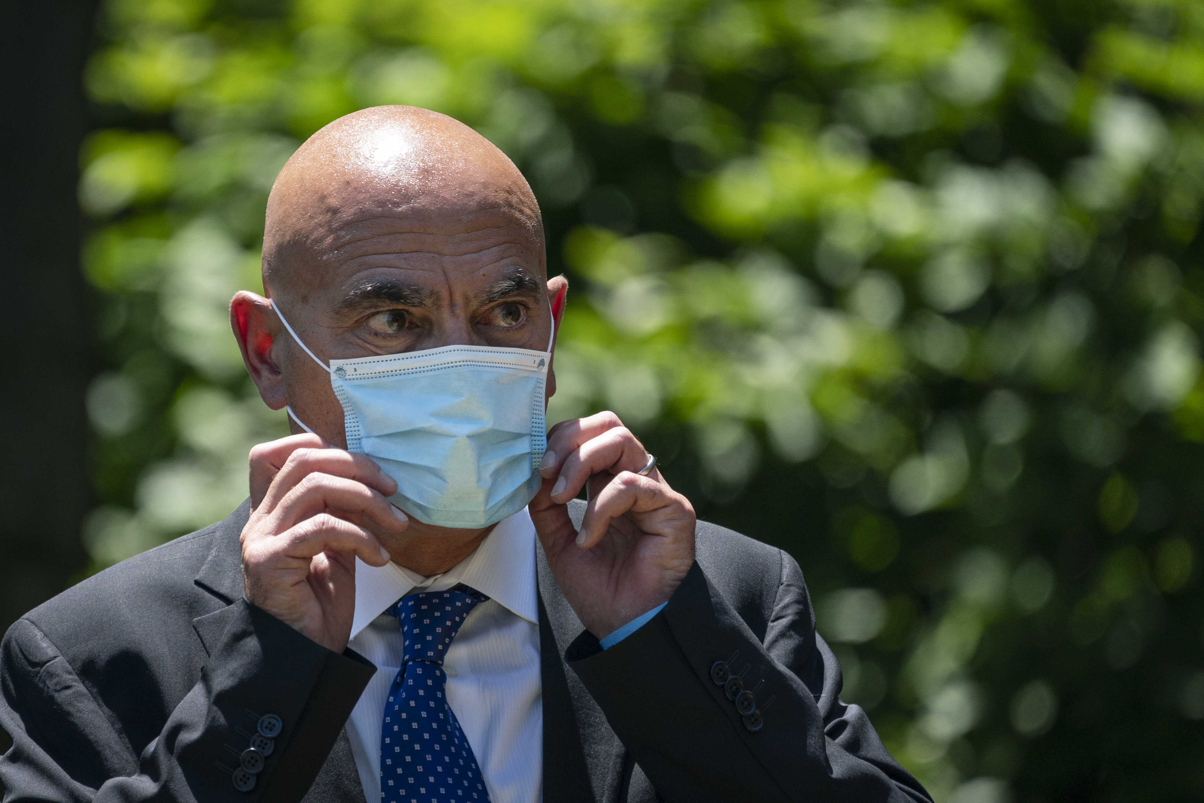 Moncef Slaoui, head of the White House's "Operation Warp Speed" project to develop a coronavirus vaccine, listens to U.S. President Donald Trump deliversremarks about vaccine development in the Rose Garden of the White House on May 15, 2020 in Washington, DC. (Drew Angerer—Getty Images)