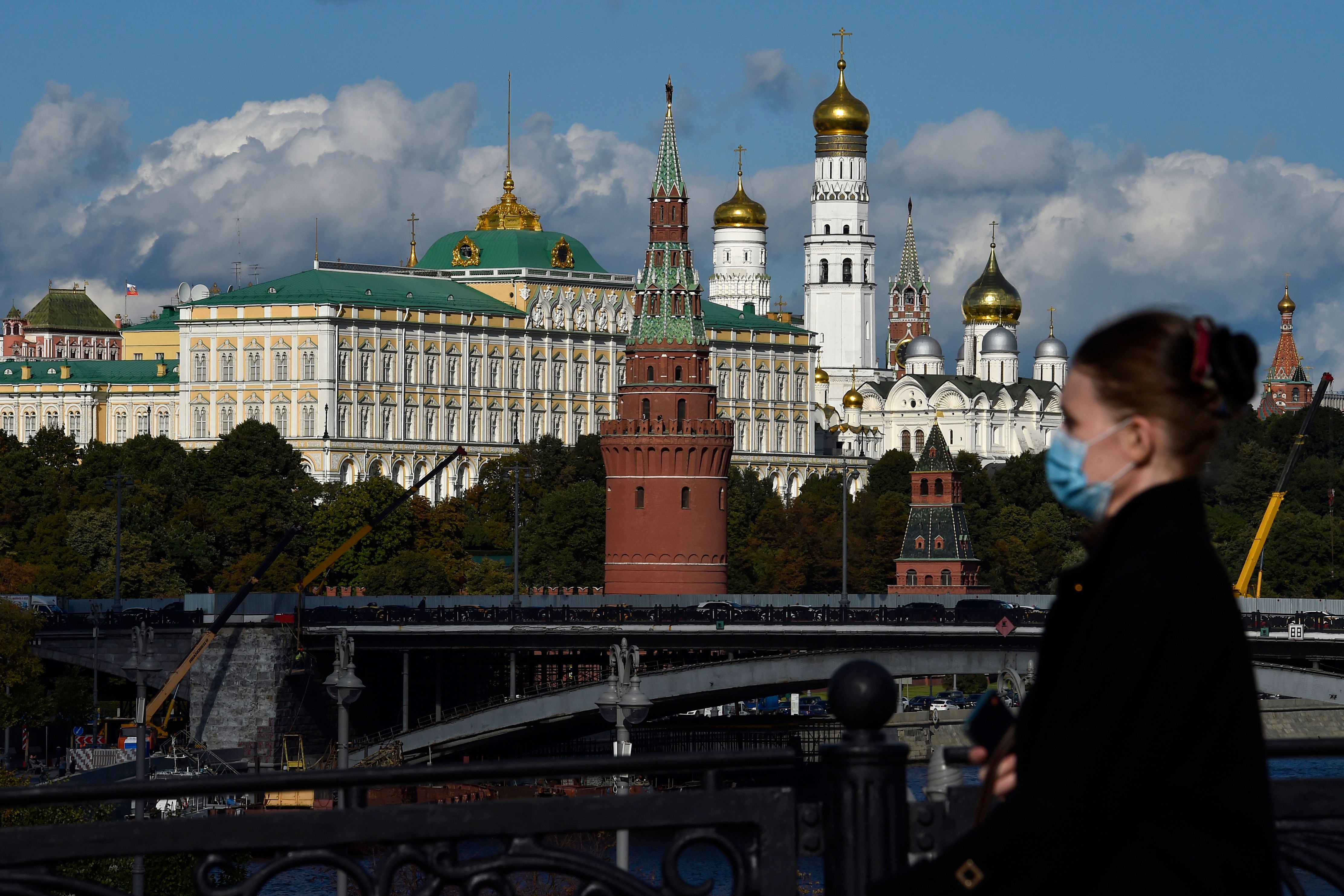 A woman wearing a face mask to protect against the coronavirus disease walks in downtown Moscow, with the Kremlin seen in the background, on Sept. 15, 2020. (Natalia Kolesnikova—AFP/Getty Images)